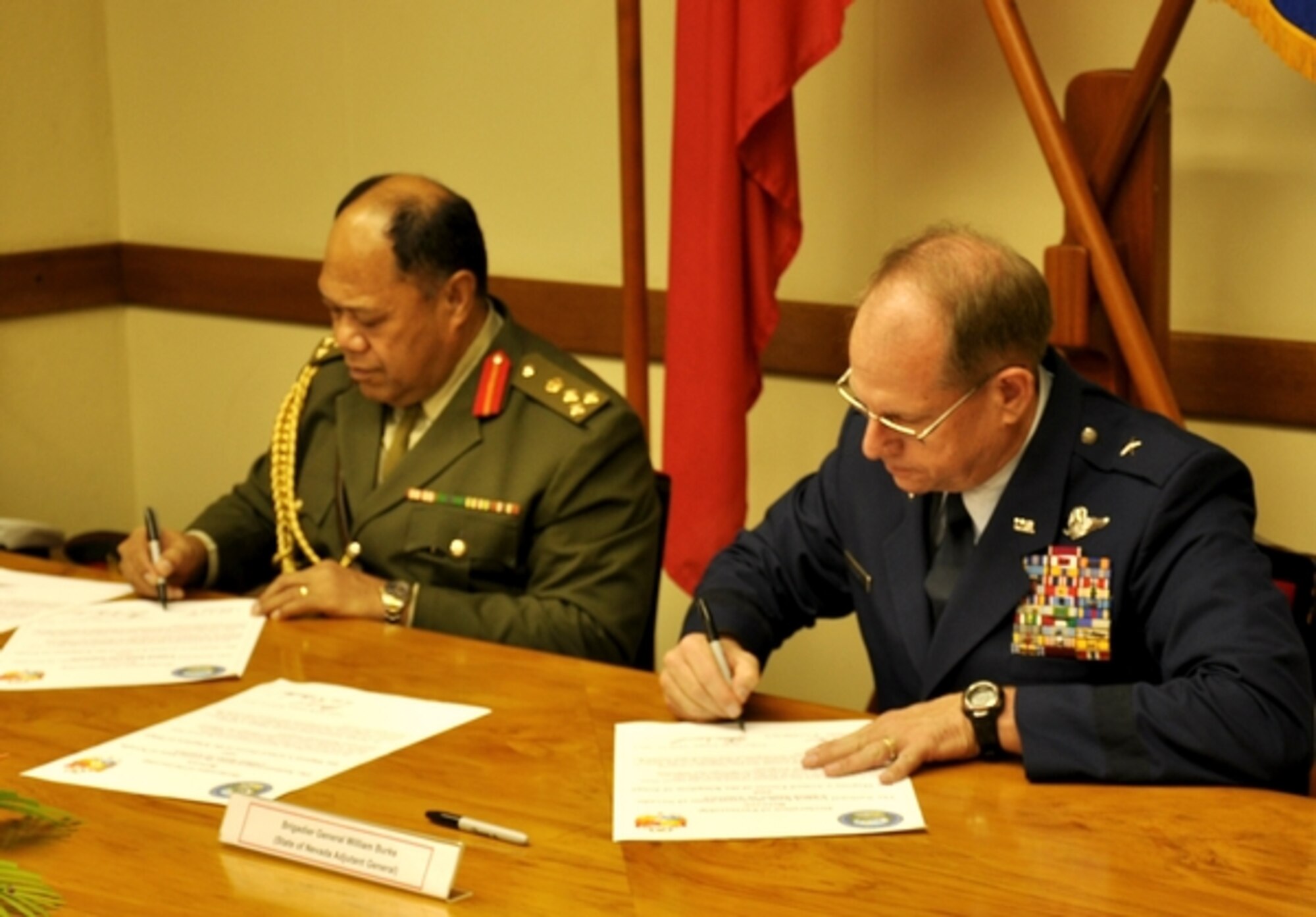 Brig. Gen. Tau’aika Uta’atu, left, the commander of Tonga’s armed forces, and Nevada Adjutant General Brig. Gen. Bill Burks, sign the documents to enter their respective parties into the State Partnership Program during a formal signing ceremony held at Armed Forces Headquarters in Nuku’alofa, Tonga, on April 11. The State Partnership Program now features 68 partnerships involving 74 nations around the world.

Photo by Maj. Dennis Fournier, Joint Force Headquarters Public Affairs
