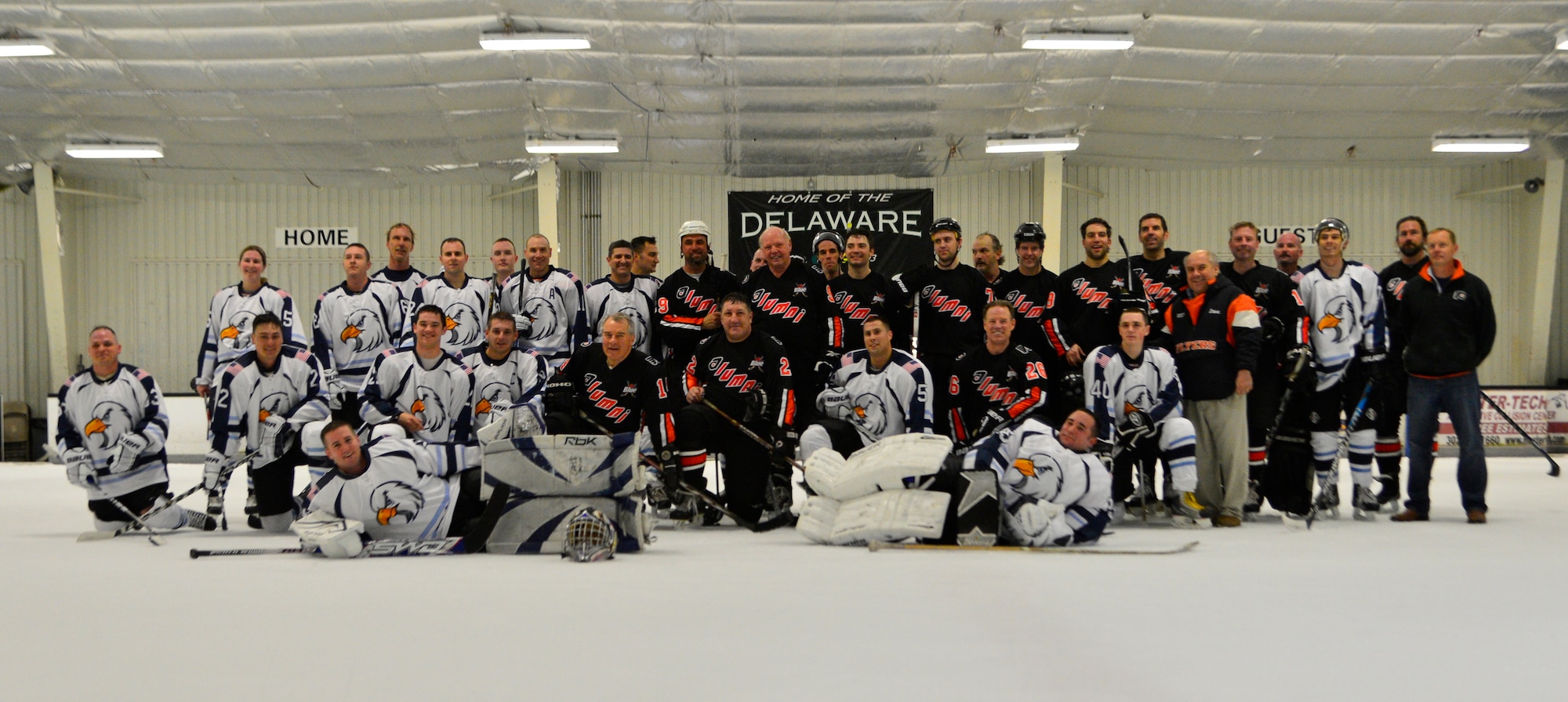 The Dover Eagles and the Flyers Alumni hockey teams pose for a photo after a charity hockey game April 12, 2014, at the Pond Ice Arena in Newark, Del. This was the third and final charity game of the season for the Eagles. (U.S. Air Force photo/Airman 1st Class William Johnson)