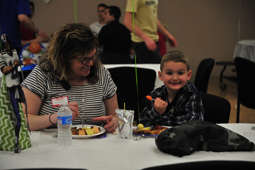 Katie Sutherland, wife of Staff Sgt. John Sutherland, 436th Security Forces Squadron, and their son Landon enjoy food and treats during the deployed spouses dinner at the Youth Center April 10, 2014, at Dover Air Force Base, Del. Approximately 40 spouses and family members of deployed Team Dover Airmen attended the event that included a bounce house, dinner, raffle drawings and sports activities. (U.S. Air Force photo/Staff Sgt. Elizabeth Morris)