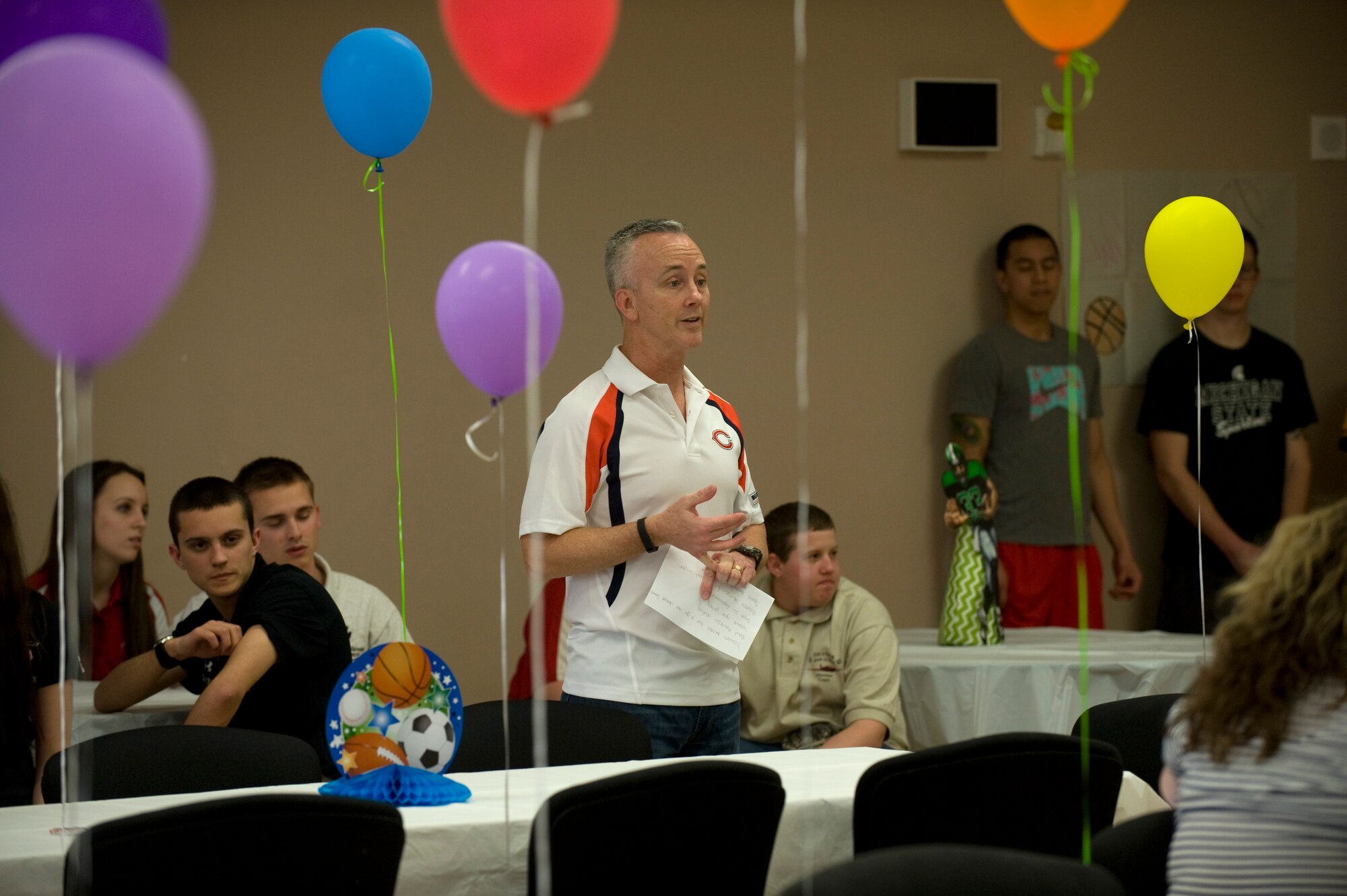 Col. Kevin Murphy, 436th Medical Group commander, welcomes spouses of deployed Team Dover Airmen to a sports themed deployed spouses dinner at the Youth Center April 10, 2014, at Dover Air Force Base, Del. Members of the 436th MDG along with athletes from the local area volunteered to help out at the event. (U.S. Air Force photo/Staff Sgt. Elizabeth Morris)