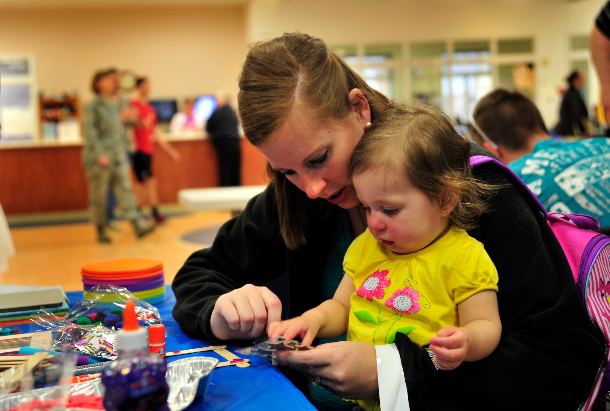 Lindsay Bischoff, wife of Airman 1st Class David Bischoff, 436th Security Forces Squadron, and their daughter Mikayla make crafts during a deployed spouses dinner at the Youth Center April 10, 2014, at Dover Air Force Base, Del. The 436th Medical Group hosted the event and had many activities for both the parents and children to participate in.(U.S. Air Force photo/Staff Sgt. Elizabeth Morris)
