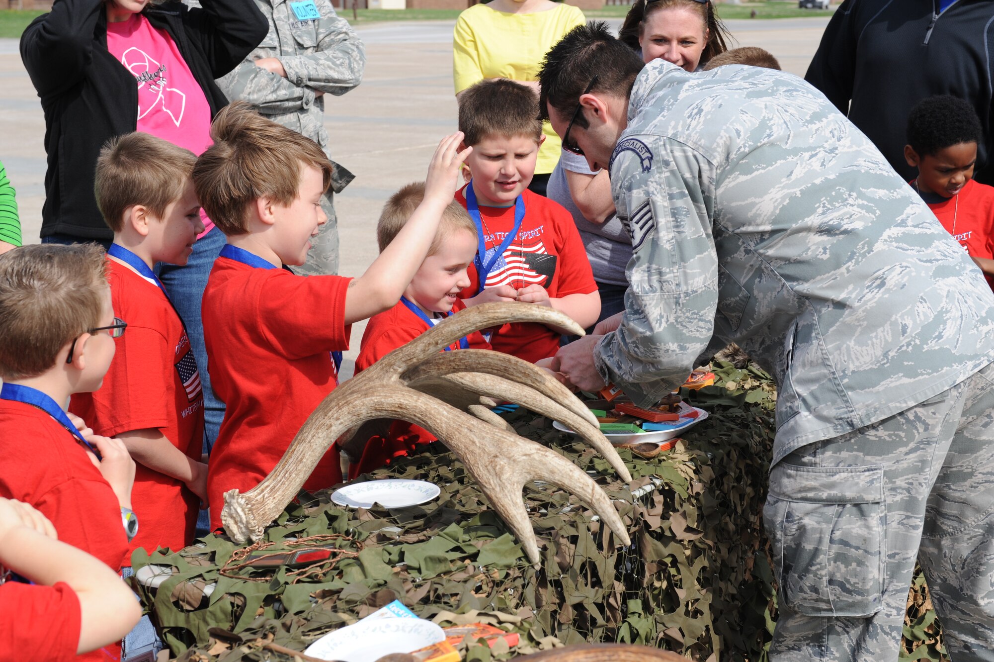 Staff Sgt. Clifton Cleveland 509th Operations Support Squadron Survival, Evasion, Resistance and Escape Specialist and event volunteer, conducts mock SERE training for the children during Operation Spirit at Whiteman Air Force Base, Mo., April 12, 2014. The children were tasked with eating at least one flavored insect to complete the training. (U.S. Air Force photo/Airman 1st Class Joel Pfiester/Released)  