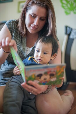 Kristin Warat, family child care provider, and Paul, one of the children she watches, read during story time, April 11, 2014,at her house in Little Creek, Del. FCC providers care for military and DoD civilian’s children from their homes. (U.S. Air Force photo/Senior Airman Jared Duhon)
