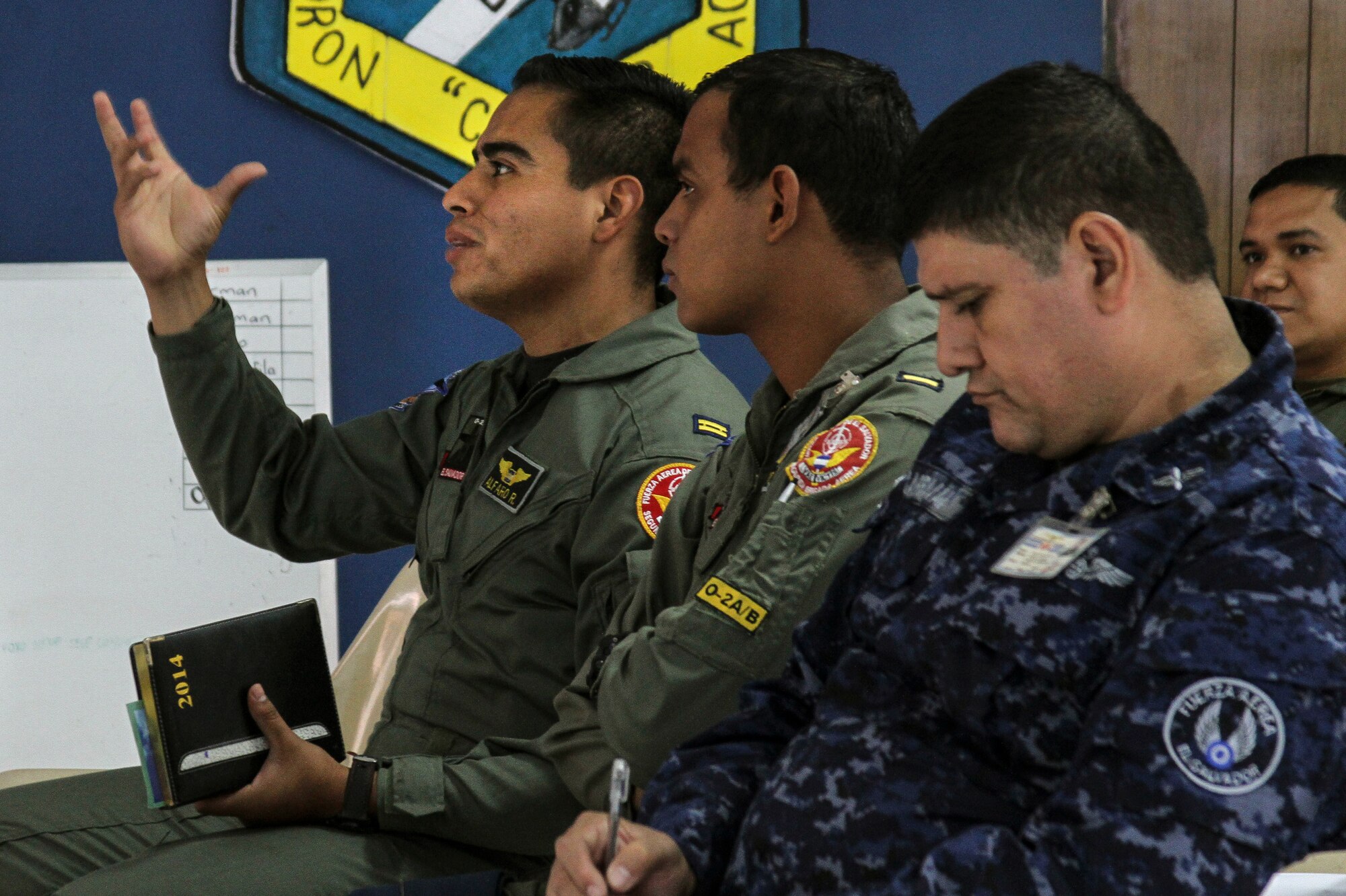 Members of the El Salvadorian Air Force ask questions and take notes during a subject matter expert exchange at Ilopango AB, El Salvador, April 2, 2014.  The subject matter expert exchange occurred from April 1-4 and included topics on imagery collection and processing. (U.S. Air Force photo by Staff Sgt. Heather Redman/Released)