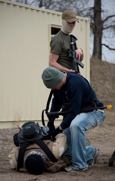 Airman 1st Class Bronson Scheff, center, secures Master Sgt. Robben Todd hands in Arden Hills, Minn., Apr. 12, 2014. Todd was going through a refresher Survival, Evasion, Resistance and Escape training exercise to maintain his proficiency with the techniques and skills that will keep him alive.
(U.S. Air National Guard photo by Tech. Sgt. Amy M. Lovgren/ Released)
