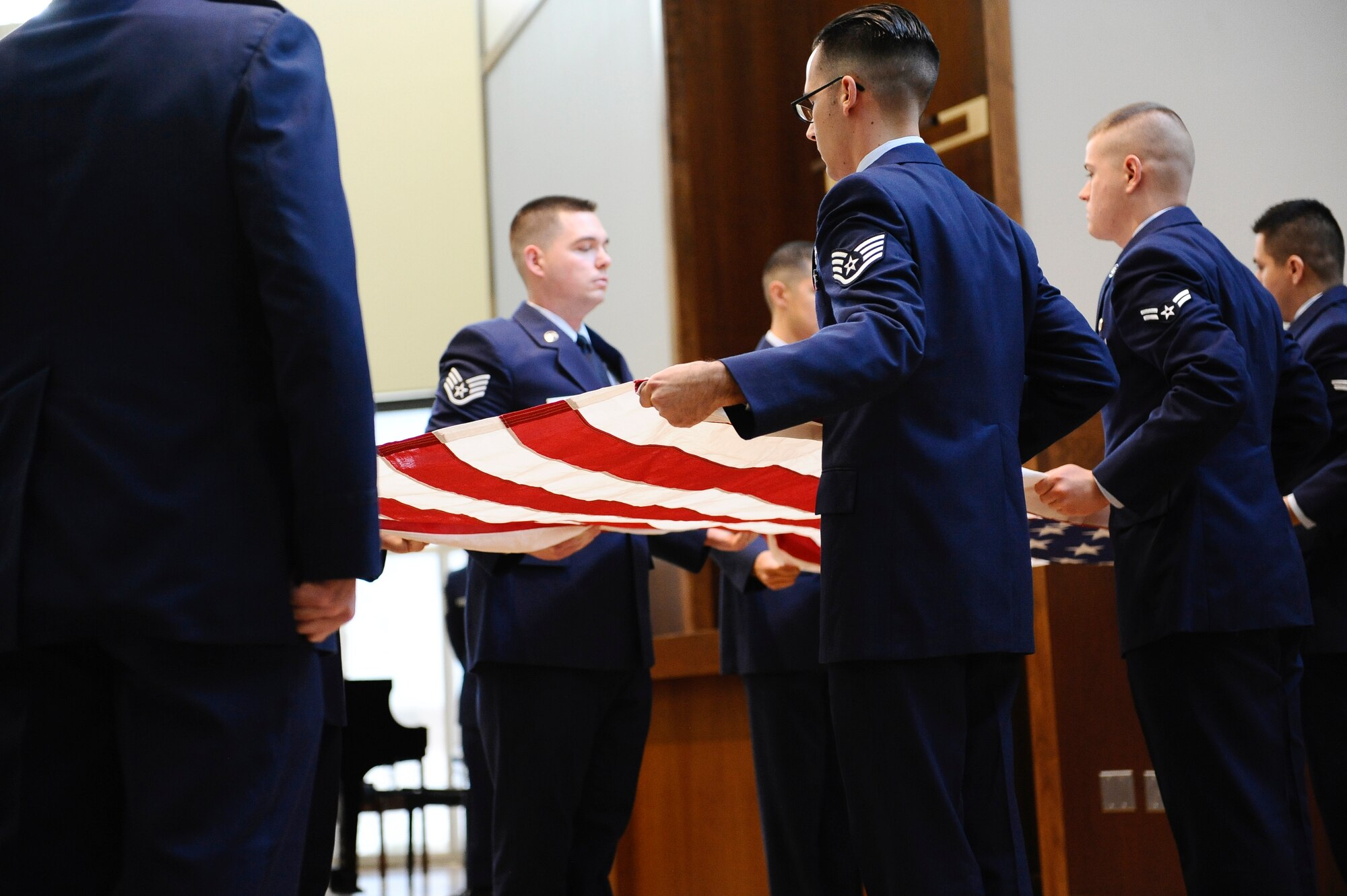Members of the 460th Space Communications Squadron Honor Guard fold a flag at the memorial service for Senior Airman Michael S. Snyder, 460th SCS cyber transport journeyman, April 14, 2014, at the base chapel on Buckley Air Force Base, Colo. Snyder, an El Paso, Ill. native, was 23 years old and had been at Buckley for two years before he was killed by an alleged drunk driver while on his motorcycle the night of April 9, 2014. (U.S. Air Force photo by Airman 1st Class Samantha Saulsbury/Released)