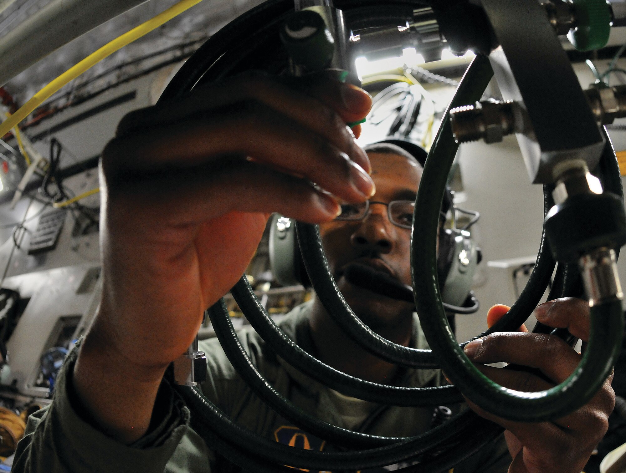 WRIGHT-PATTERSON AIR FORCE BASE, Ohio - Senior Airman Lawrence Mark, 445th Aeromedical Evacuation Squadron, coils oxygen tubing next to a litter patient to be used as needed during in-flight treatment on board a C-17 Globemaster III training flight Feb. 22. The C-17 is masterfully designed to be used for medical evacuation. The aircraft has electrical and oxygen hooks-ups built in. (U.S. Air Force photo/Tech. Sgt. Frank Oliver)