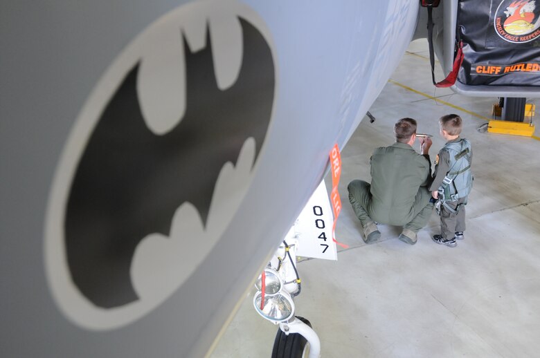 Maj. Richard Giampietri, a 114th Fighter Squadron Pilot shows Fighter Pilot for a Day Miles Scott, call sign, “Batkid” a replica of a live shell the F-15 carries as part of its armament at the 173rd Fighter Wing, April 10, 2014. The jet bears a batman symbol which crew chief Tech. Sgt. Cliff Rutledge had affixed to the jet in honor of Scott’s visit. Scott has battled leukemia and his doctors have recently said he is in remission. (U.S. Air Force photo by Tech. Sgt. Jefferson Thompson/released)