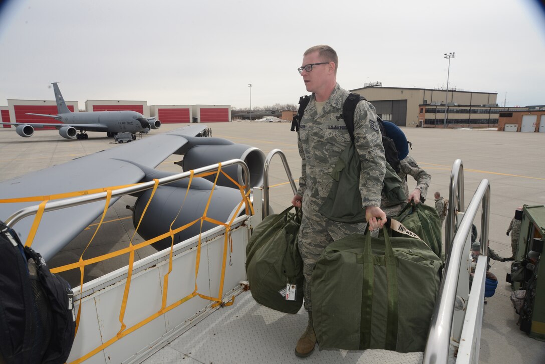 Staff Sgt. Jacob Backer, of the 119th Civil Engineer Squadron, carries baggage onto a KC-135 aircraft as he prepares to travel to the Silver Flag civil engineer training site at Tyndall Air Force Base, Fl., March 28, 2014. (U.S. Air National Guard photo by SMSgt. David H. Lipp/Released)