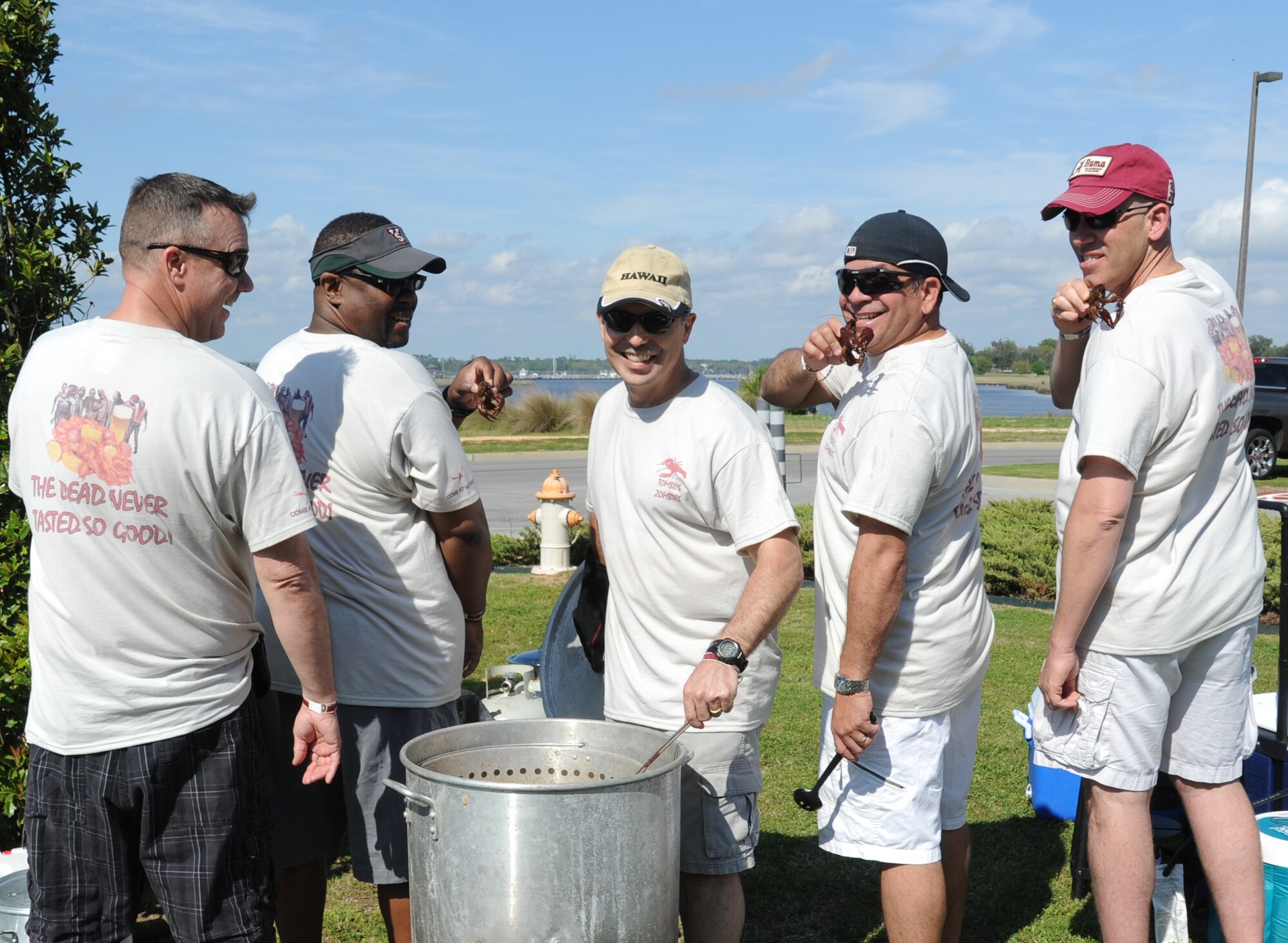 Col. George Tombe, (center), 81st Training Group commander, and his “Tombes Zombies” team-mates, Lt. Col. Jeffrey McLemore, Kurt Higgins, and Chief Master Sgts.Eleizer Santos and Robert Winters, take a photo donning  team T-shirts during the 2nd Annual Bay Breeze Crawfish Cook-Off April 11, 2014, at the Bay Breeze Event Center, Keesler Air Force Base, Miss.  The trophy was taken by the “Cajun Snappa” team, who will receive a free entry into the 22nd Annual Mississippi Coast Coliseum Crawfish Festival Cook-Off.  (U.S. Air Force photo by Kemberly Groue)