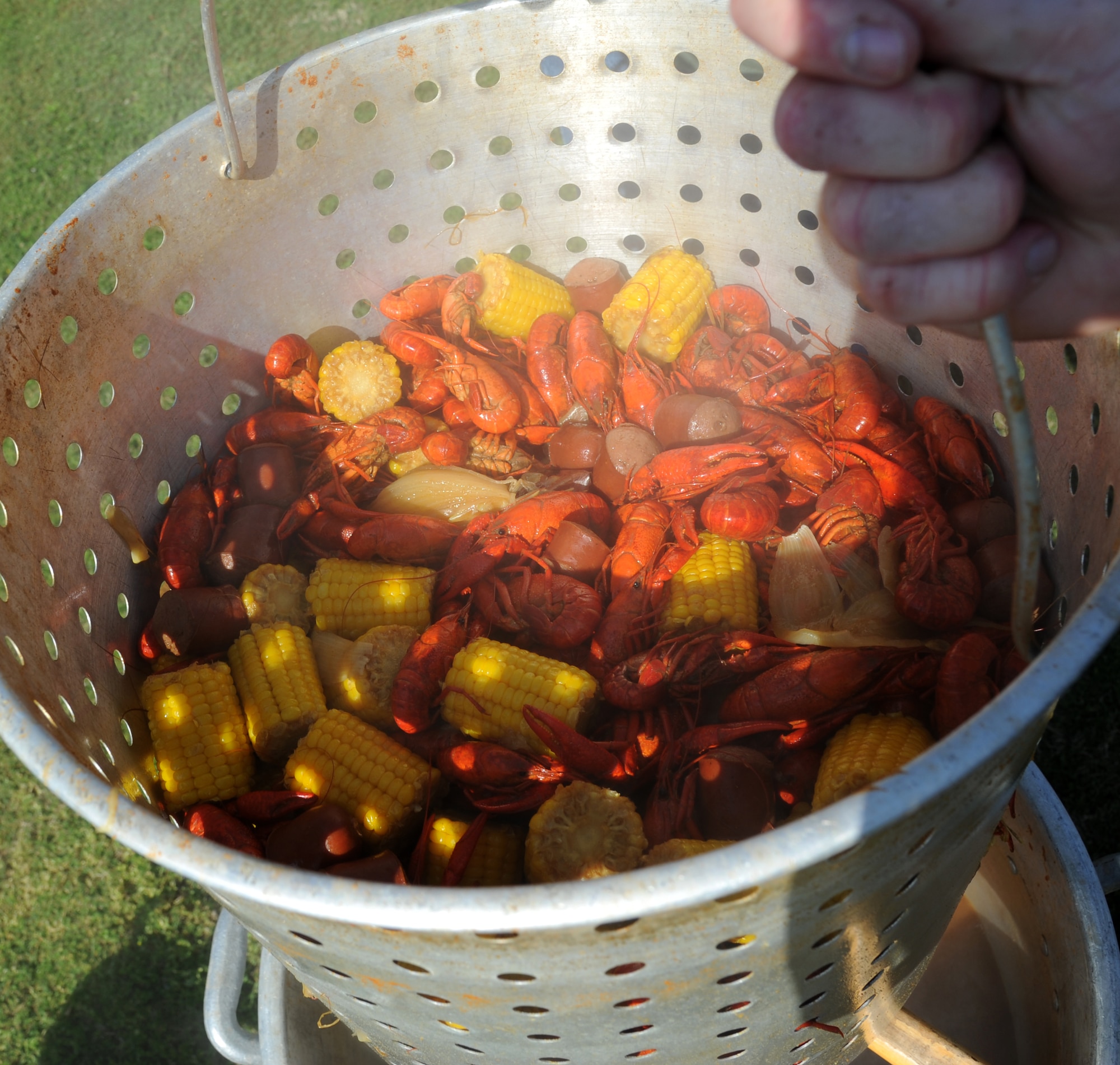 A pot of freshly boiled crawfish with the ‘fixins’ is pulled out of the boil during the 2nd Annual Bay Breeze Crawfish Cook-Off April 11, 2014, at the Bay Breeze Event Center, Keesler Air Force Base, Miss. The trophy was taken by the “Cajun Snappa” team, who will receive a free entry into the 22nd Annual Mississippi Coast Coliseum Crawfish Festival Cook-Off.  (U.S. Air Force photo by Kemberly Groue)
