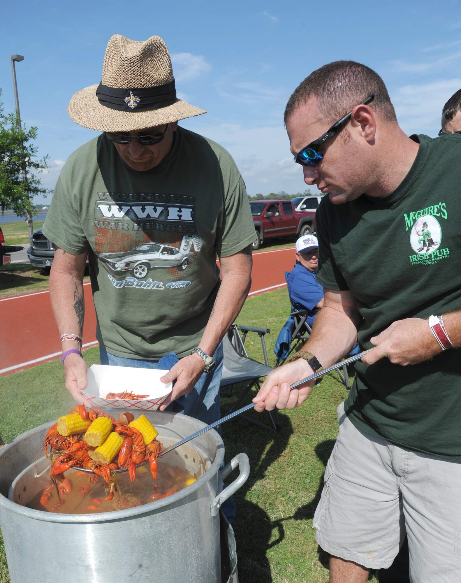 Larry LaCrouts and his nephew, Staff Sgt. Stephen McClellan, 85th Engineering Installation Squadron, scoop out a fresh batch of boiled crawfish with the ‘fixins’ for sampling during the 2nd Annual Bay Breeze Crawfish Cook-Off April 11, 2014, at the Bay Breeze Event Center, Keesler Air Force Base, Miss. The trophy was taken by the “Cajun Snappa” team, who will receive a free entry into the 22nd Annual Mississippi Coast Coliseum Crawfish Festival Cook-Off.  (U.S. Air Force photo by Kemberly Groue)