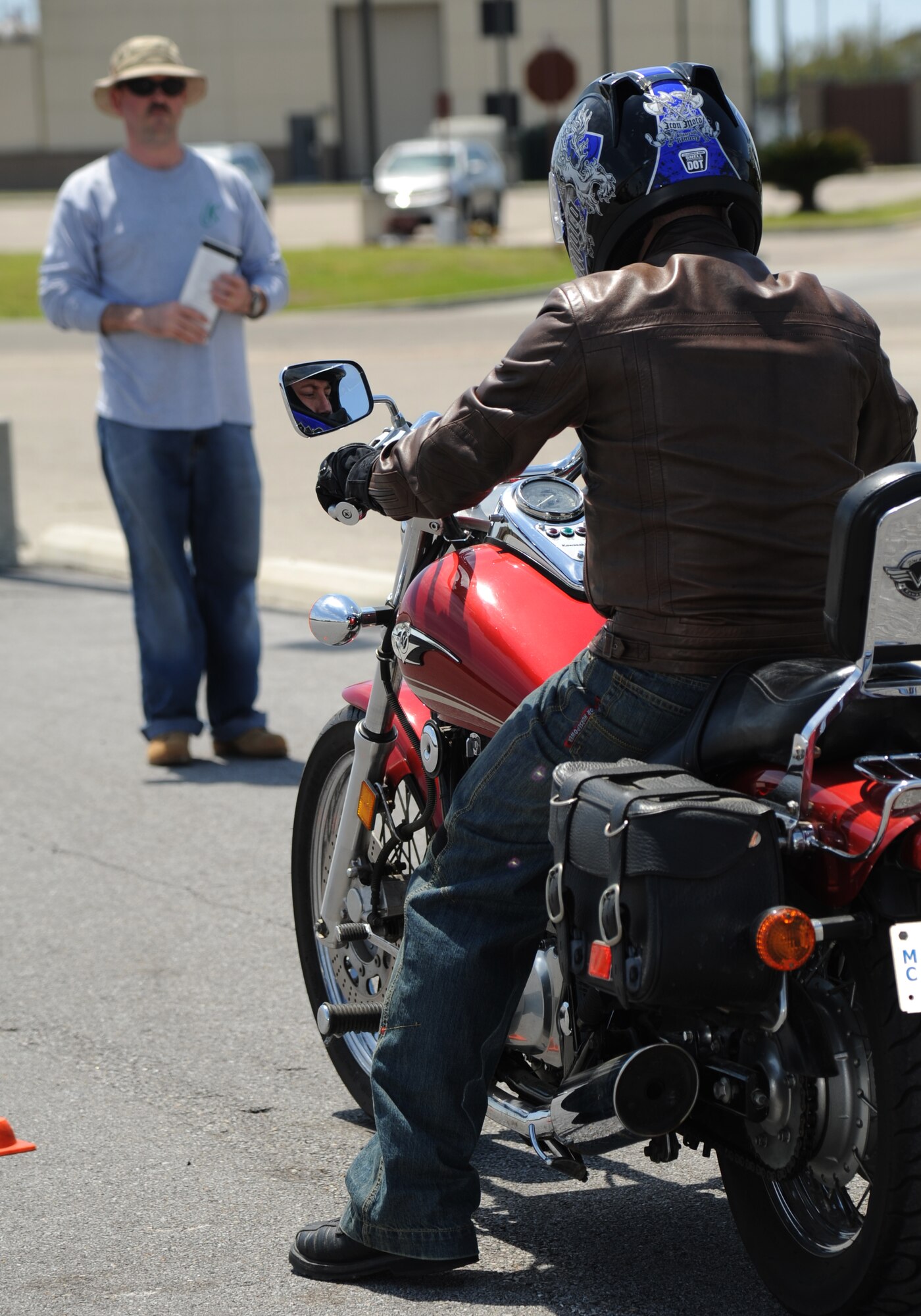Tech. Sgt. Michael Farmer, 81st Training Support Squadron and motorcycle safety course instructor, takes his spot on the course boundaries while Senior Airman Blake Pittman, 81st Contracting Squadron, prepares to navigate the course during a motorcycle safety course April 11, 2014, at Keesler Air Force Base, Miss.  The course is offered twice a month and teaches students the basic operating skills and safety rules for riding a motorcycle.  (U.S. Air Force photo by Kemberly Groue)