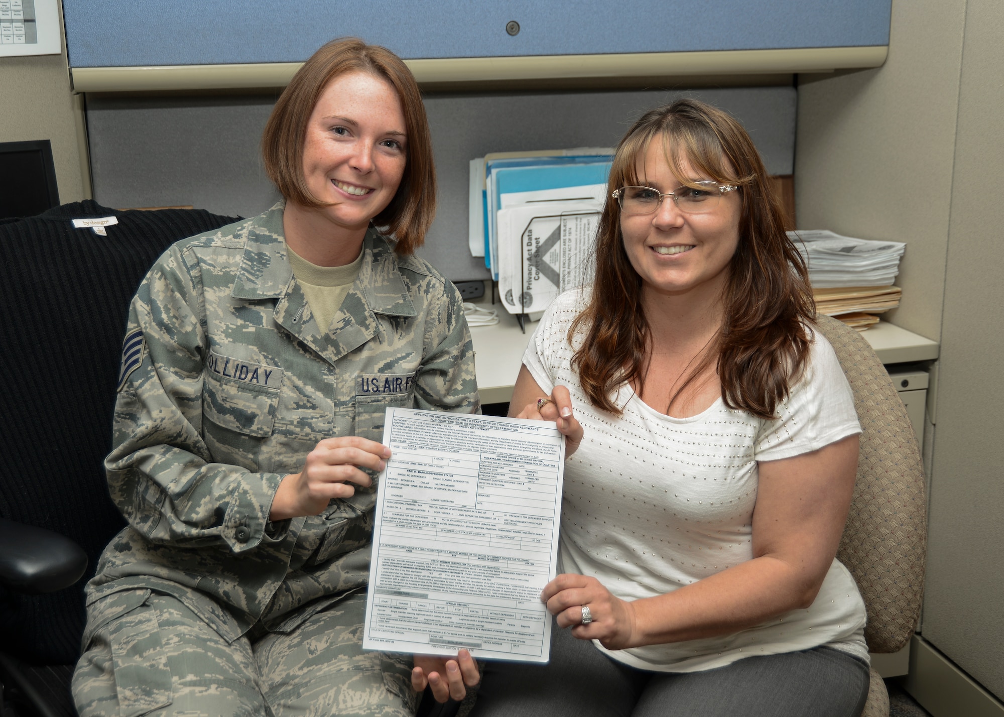 Staff Sgt. Tiffany Holliday (left), 412th Comptroller Squadron, Financial Services supervisor, and Wende Wagner, Financial Management analyst, show the Air Force Form 594, which is required to validate Airmen’s basic allowance for housing entitlements. (U.S. Air Force photo by Rebecca Amber)