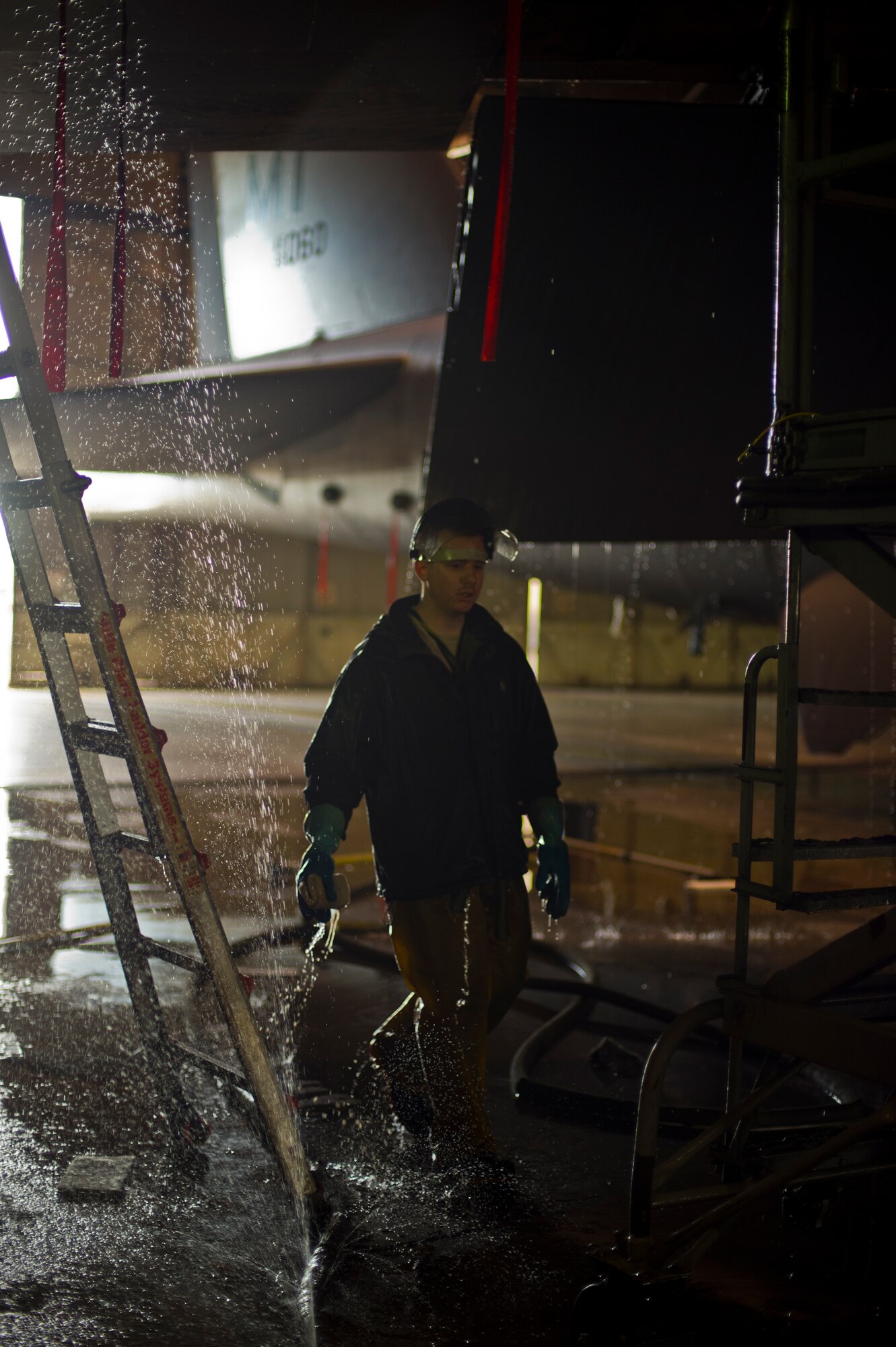 Airman 1st Class Daniel Starr, 5th Aircraft Maintenance Squadron crew chief, walks underneath a B-52H Stratofortress during a wash at Minot Air Force Base, N.D., March 10, 2014. The 5th AMS consists of two aircraft maintenance unit specialist sections, the 23rd and 69th AMU with a total of 237 maintenance professionals spanning across six Air Force specialties including Communications/Navigation, Instruments/Flight Controls, Electronic Counter Measures, Jet Engine Mechanics, Hydraulics and Electrical/Environmental systems. (U.S. Air Force photo/Senior Airman Brittany Y. Auld)