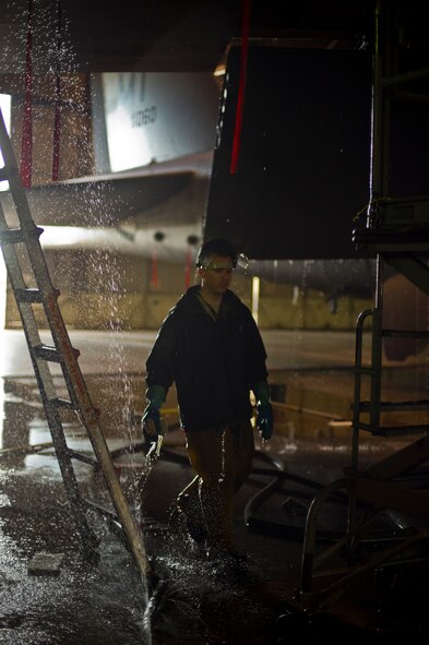 Airman 1st Class Daniel Starr, 5th Aircraft Maintenance Squadron crew chief, walks underneath a B-52H Stratofortress during a wash at Minot Air Force Base, N.D., March 10, 2014. The 5th AMS consists of two aircraft maintenance unit specialist sections, the 23rd and 69th AMU with a total of 237 maintenance professionals spanning across six Air Force specialties including Communications/Navigation, Instruments/Flight Controls, Electronic Counter Measures, Jet Engine Mechanics, Hydraulics and Electrical/Environmental systems. (U.S. Air Force photo/Senior Airman Brittany Y. Auld)