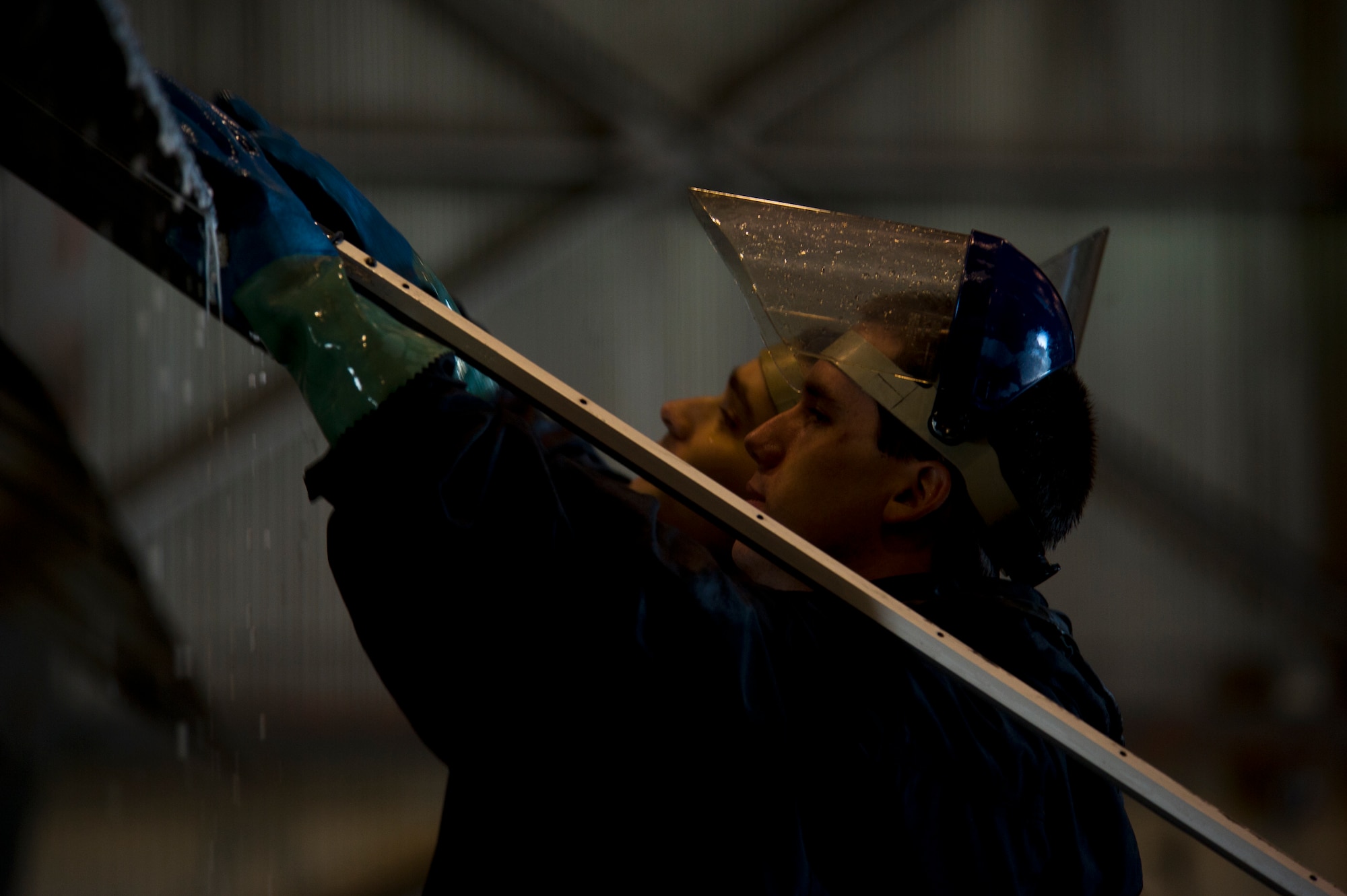 Airmen 1st Class Daniel Starr and Zachary West, 5th Aircraft Maintenance Squadron crew chiefs, wash a B-52H Stratofortress at Minot Air Force Base, N.D., March 10, 2014. After the wash is completed, post wash lube is used to force water and collected dirt out of high friction and moving areas. This keeps the parts functioning properly for safety during flights.  (U.S. Air Force photo/Senior Airman Brittany Y. Auld)