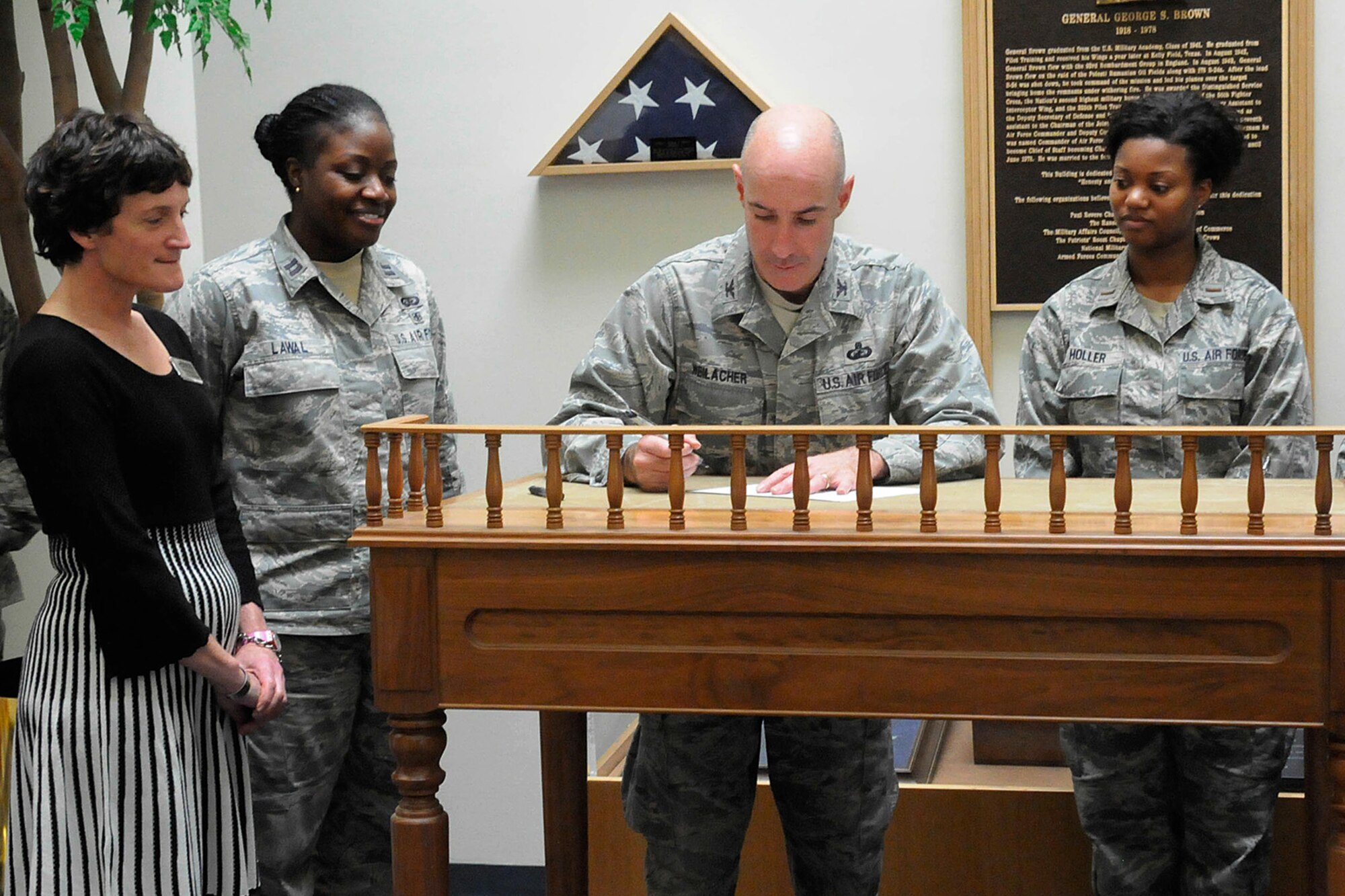 HANSCOM AIR FORCE BASE, Mass. – Col. Lester A. Weilacher, 66th Air Base Group commander, signs a proclamation declaring April 28 through May 2 as the Holocaust Days of Remembrance on base as (left to right) Linda Ambard, Capt. Joy Lawal and 2nd Lt. Shaina Holler look on. As part of the observance a Holocaust survivor will speak April 28 at 11 a.m. at the Hanscom Conference Center. (U.S. Air Force photo by Linda LaBonte Britt)
