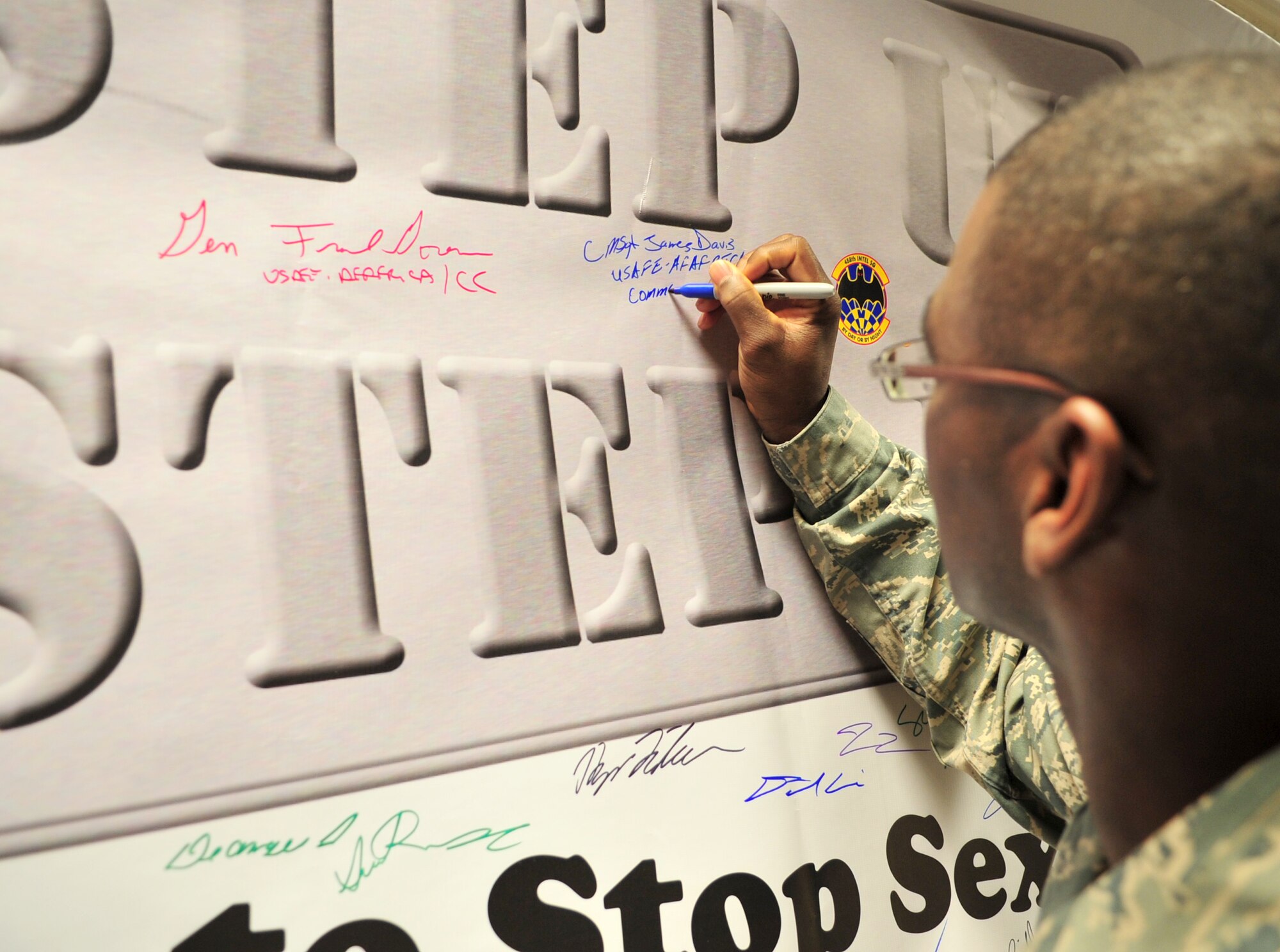 U.S. Air Force Chief Master Sgt. James E. Davis, U.S. Air Forces in Europe and Air Forces Africa command chief, signs Team Mildenhall’s Step Up and Step In banner April 14, 2014, during a visit to RAF Mildenhall, England. The banner represents Team Mildenhall’s commitment to eliminating sexual assault from the base. (U.S. Air Force photo by Staff Sgt. Krystie Martinez/Released)
