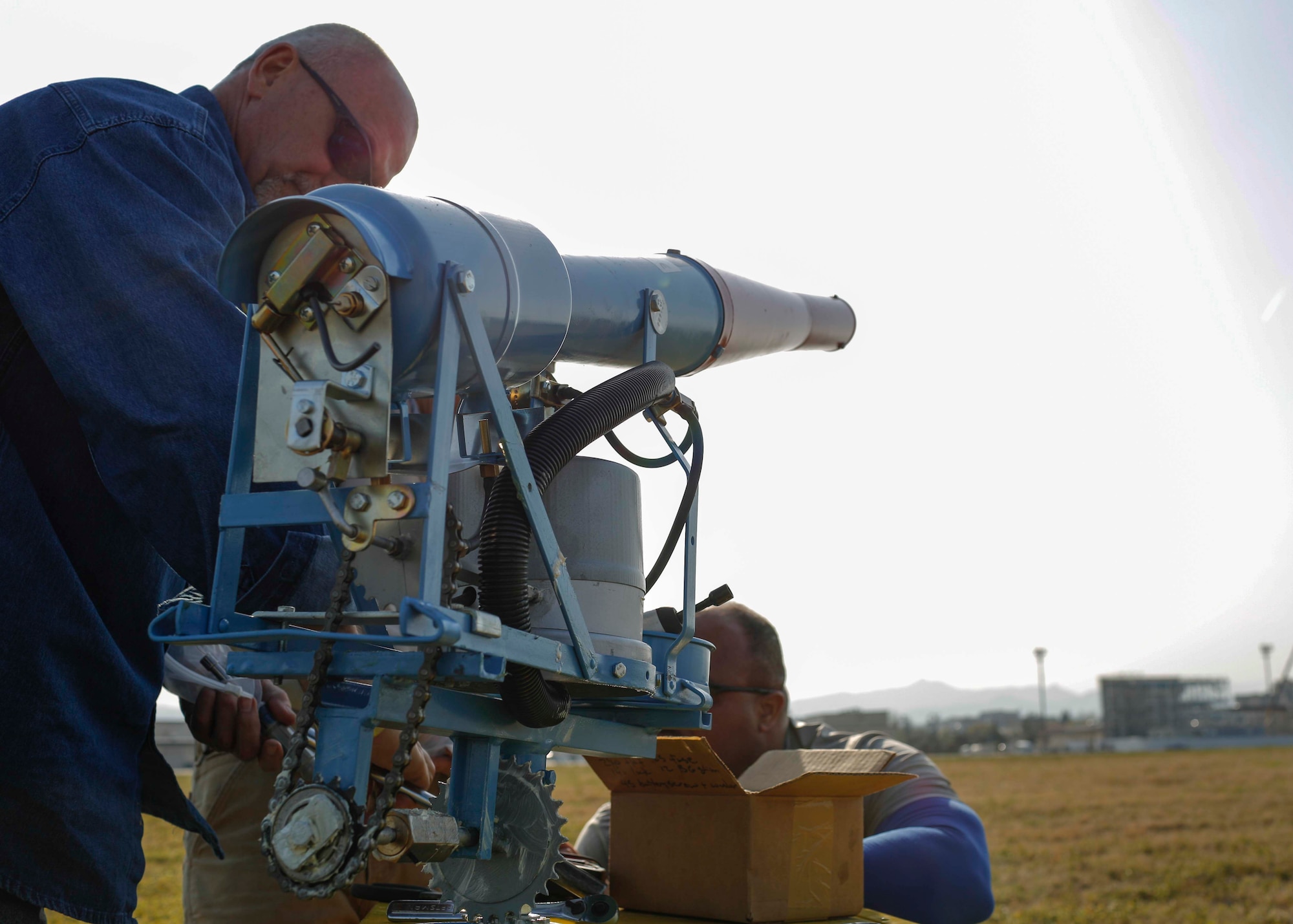 Technicians install one of 22 new Bird/Wildlife Aircraft Strike Hazard cannons at Yokota Air Base, Japan, April 11, 2014.  The BASH cannons simulate threatening sounds, such as predator calls and explosions, to scare wildlife away and mitigate possible damage to aircraft during take-off and landing.  (U.S. Air Force photo by Airman 1st Class Soo C. Kim / Released)
