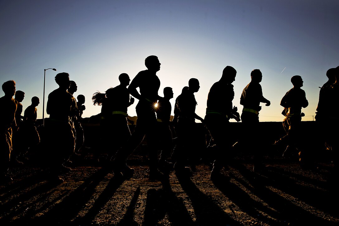 Marines participate in a three-mile training run along a fitness test track at Marine Corps Air Ground Combat Center, Twentynine Palms, Calif., April 4, 2014. The purpose of the run was to foster esprit de corps within the battalion, build unit cohesion and condition physical performance. The Marines are assigned to Headquarters Battalion. 