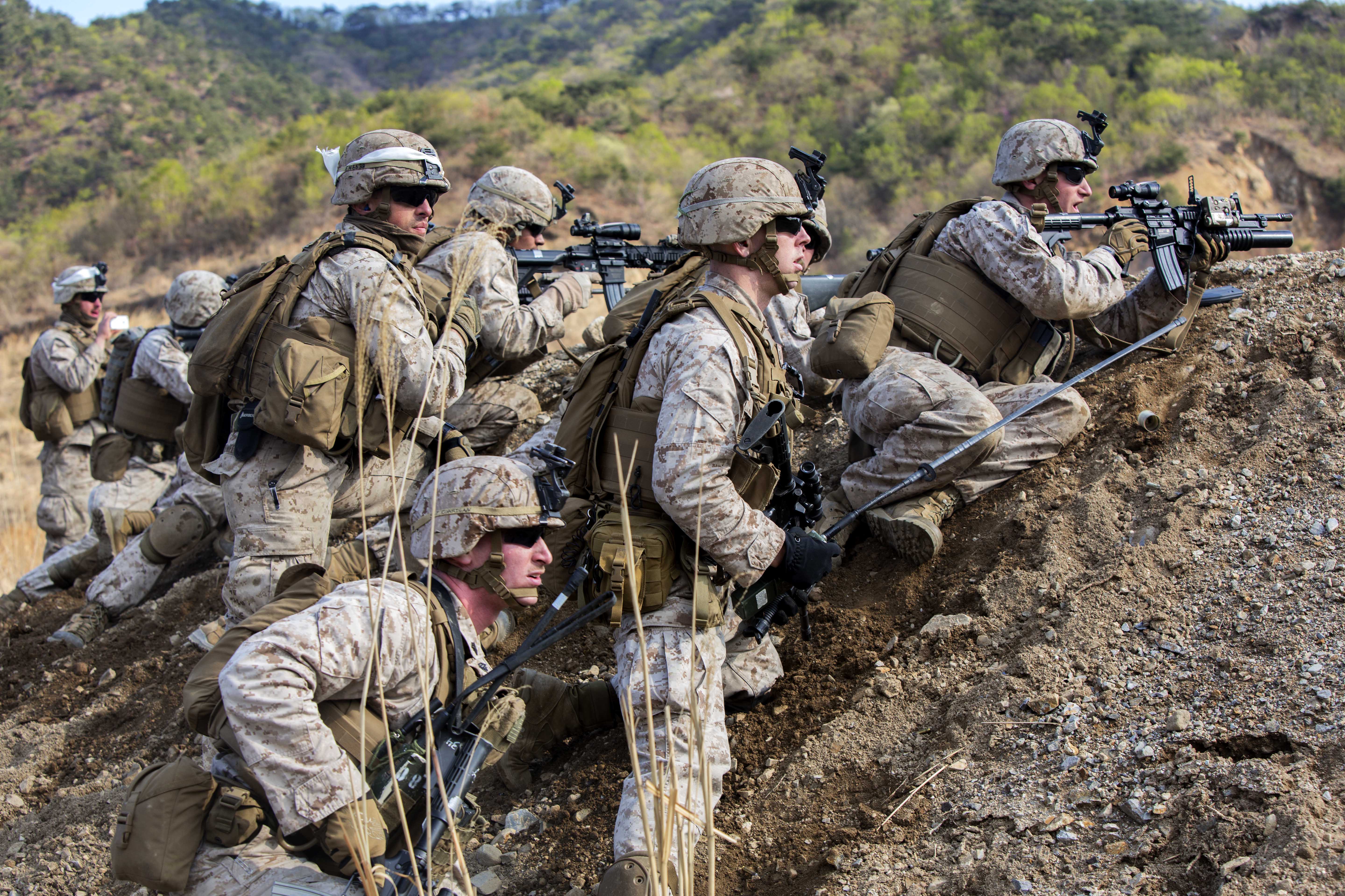 U.S. Marines take cover behind a berm while conducting live-fire ...