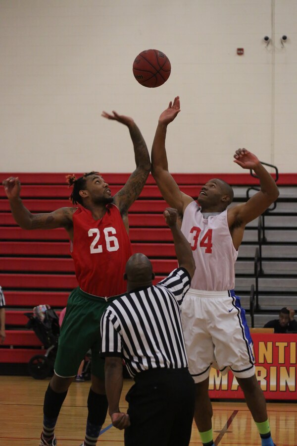 Players from Quantico’s National and American Leagues Intramural Basketball Teams jump for the ball during the tipoff of the 2014 Quantico Intramural All-Star Basketball Game on April 7, 2014. The National League won the game with a final score of 51-42.