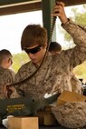 Pfc. Delaney Mulroy, a combat engineer with Alpha Company, 8th Engineer Support Battalion, 2nd Marine Logistics Group prepares ammunition prior to firing at a machine gun range aboard Camp Lejeune, N.C., April 14, 2014.  The training helped familiarize the Marines with various weapons systems commonly used throughout the Marine Corps. (U.S. Marine Corps photo by Cpl. Shawn Valosin)