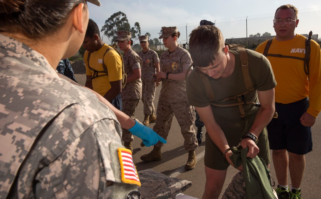 Cpl. Braden Todd, a powerline technician with Marine Fighter Attack Training Squadron 101, stuffs uniform items into a sea bag at the Naval Consolidated Brig for a simulated processing station during The Great Sexual Assault Prevention and Response Race aboard Marine Corps Air Station Miramar, Calif., April 15. The station was designed to be as accurate as possible so participants could get a true understanding of what it would be like to be convicted of sexual assault. 
