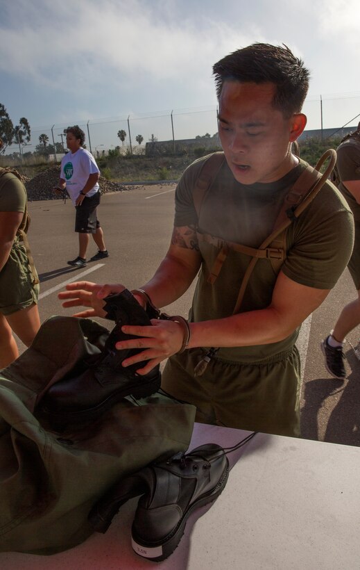 Sgt. Hai Vuong, an imagery analyst with Marine Wing Headquarters Squadron 3, stuffs uniform items into a sea bag at the Naval Consolidated Brig for a simulated processing station during The Great Sexual Assault Prevention and Response Race aboard Marine Corps Air Station Miramar, Calif., April 15. While at the brig’s station, race participants were treated as criminals convicted of sexual assault and were put through a simulated processing to show the consequences of committing sexual assault.