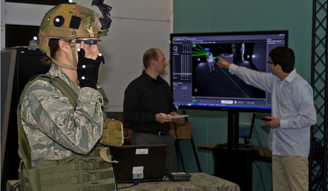 Dr. Gregory Burnett (middle) and Andres Calvo (right) analyze a graphic representation of movement trackers, as 2nd Lt. Krystin Shanklin tests Google Glass at Wright-Patterson Air Force Base, Ohio. Burnett is the chief engineer of the Battlefield Air Targeting, Man-Aided Knowledge, or BATMA(N) group, an advanced technology demonstration and research program at the 711 Human Performance Wing at the Air Force Research Laboratory. The team investigates emerging technologies, such as Google Glass' transparent, heads-up display, for possible military application. Calvo is a software developer and civilian contractor with the Wing. (U.S. Air Force photo/ Richard Eldridge)
