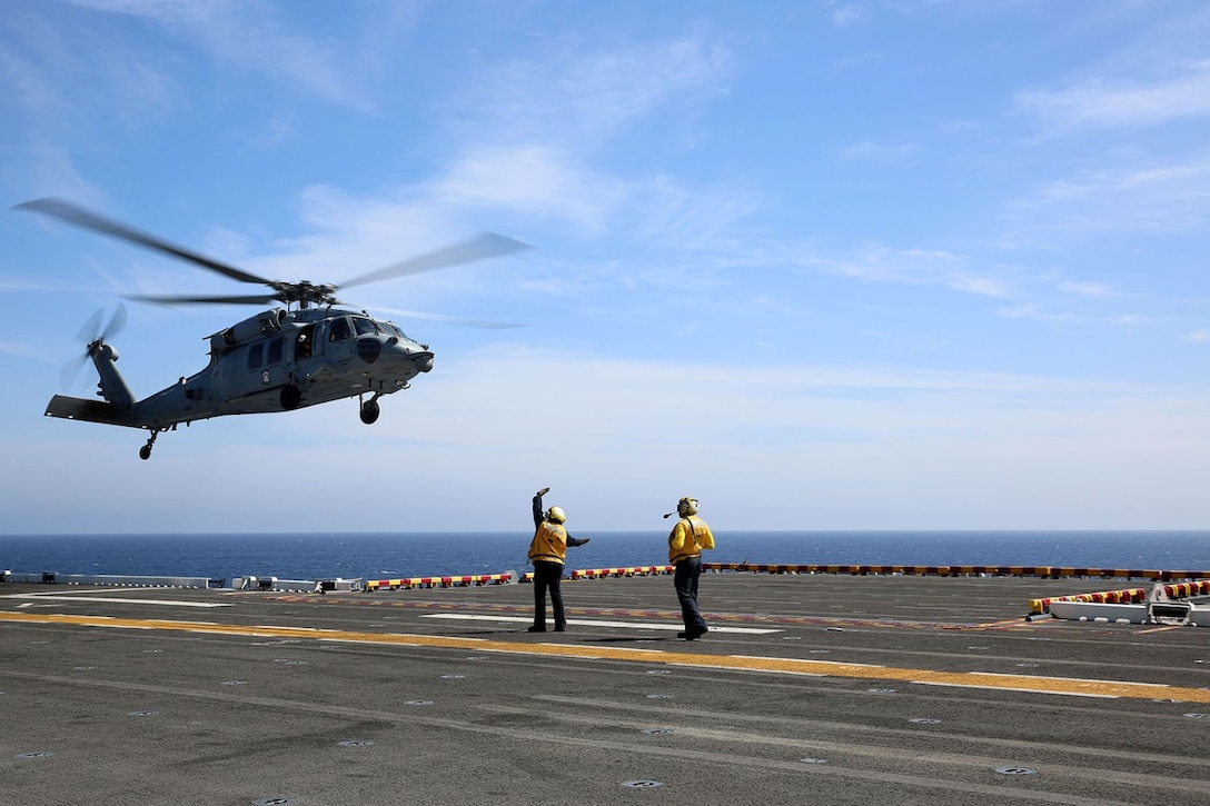 Sailors aboard the USS Makin Island direct an MH-60S Sea Hawk from the ship’s flight deck during Amphibious Squadron Marine Expeditionary Unit Integration Training (PMINT) off the coast of San Diego, April 15. The 11th Marine Expeditionary Unit and its counterpart, Amphibious Squadron 5, execute various sea-based missions as part of PMINT. (U.S. Marine Corps photo by Sgt. Melissa Wenger/Released)