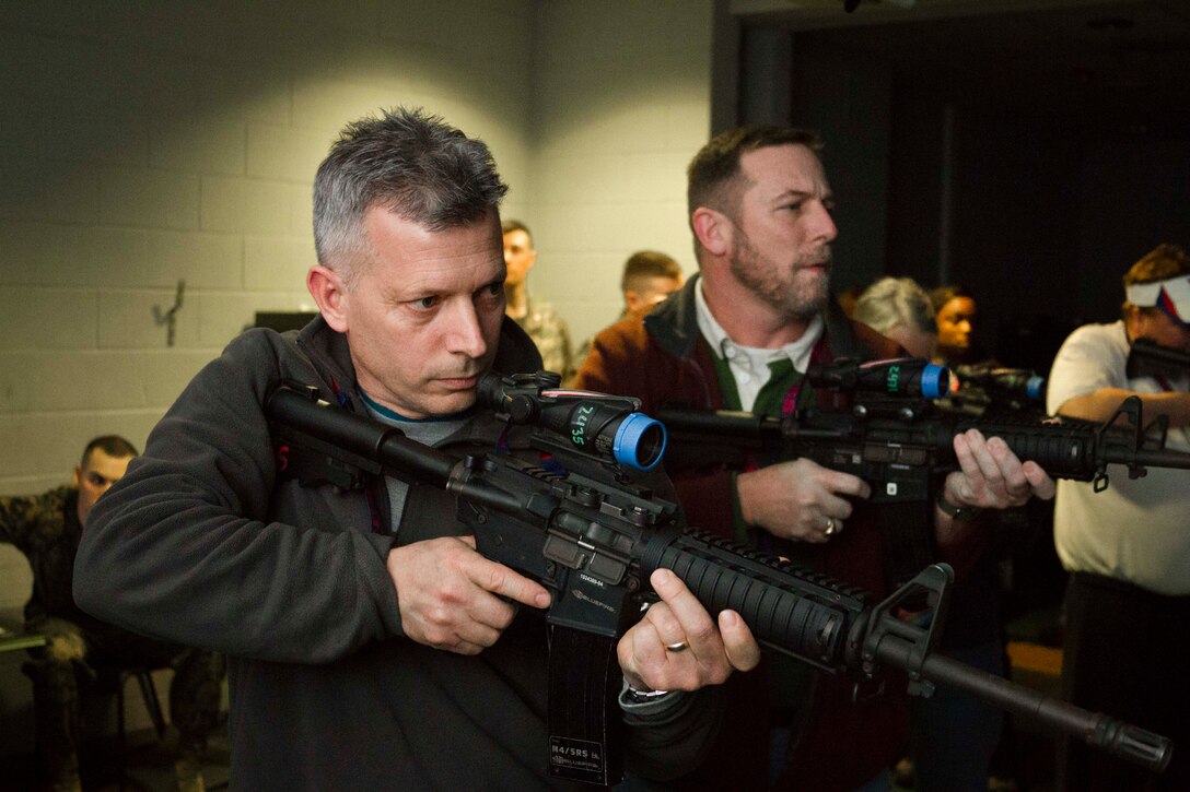 Robert Henderson, left, and Edward Cockrell, both social studies teachers at Leonardtown High School in Leonardtown, Md., take aim with M4 carbines at the indoor simulated marksmanship training facility during the first day of Recruiting Station Baltimore’s Educators Workshop at Marine Corps Recruit Depot Parris Island, S.C. The Educators Workshop is a four-day event that is intended to offer educators a practical knowledge of the Marine Corps and impress upon them the continual need to recruit highly qualified men and women. (U.S. Marine Corps photo by Sgt. Bryan Nygaard/Released)
