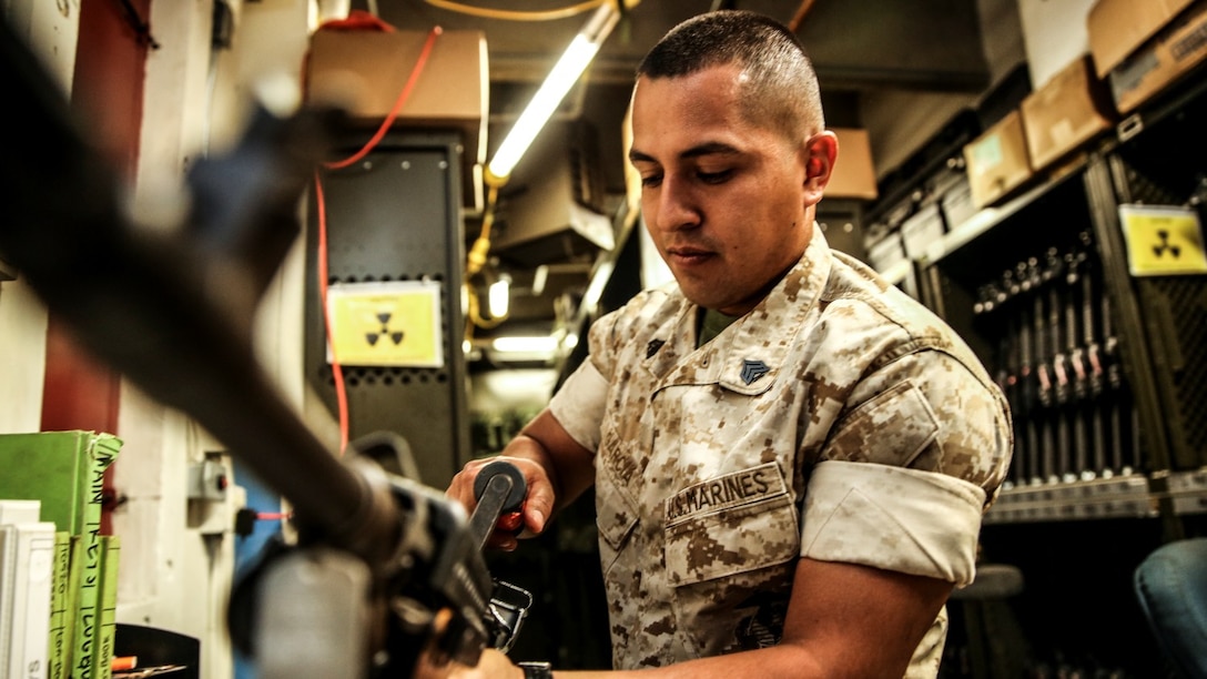 Sgt. Sigilfredo Garcia, small-arms technician, 15th Marine Expeditionary Unit, disassembles an M240B machine gun aboard Camp Pendleton, Calif., April 11, 2014. Garcia, 26, is from Watsonville, Calif. (U.S. Marine Corps photo by Cpl. Emmanuel Ramos/Released)