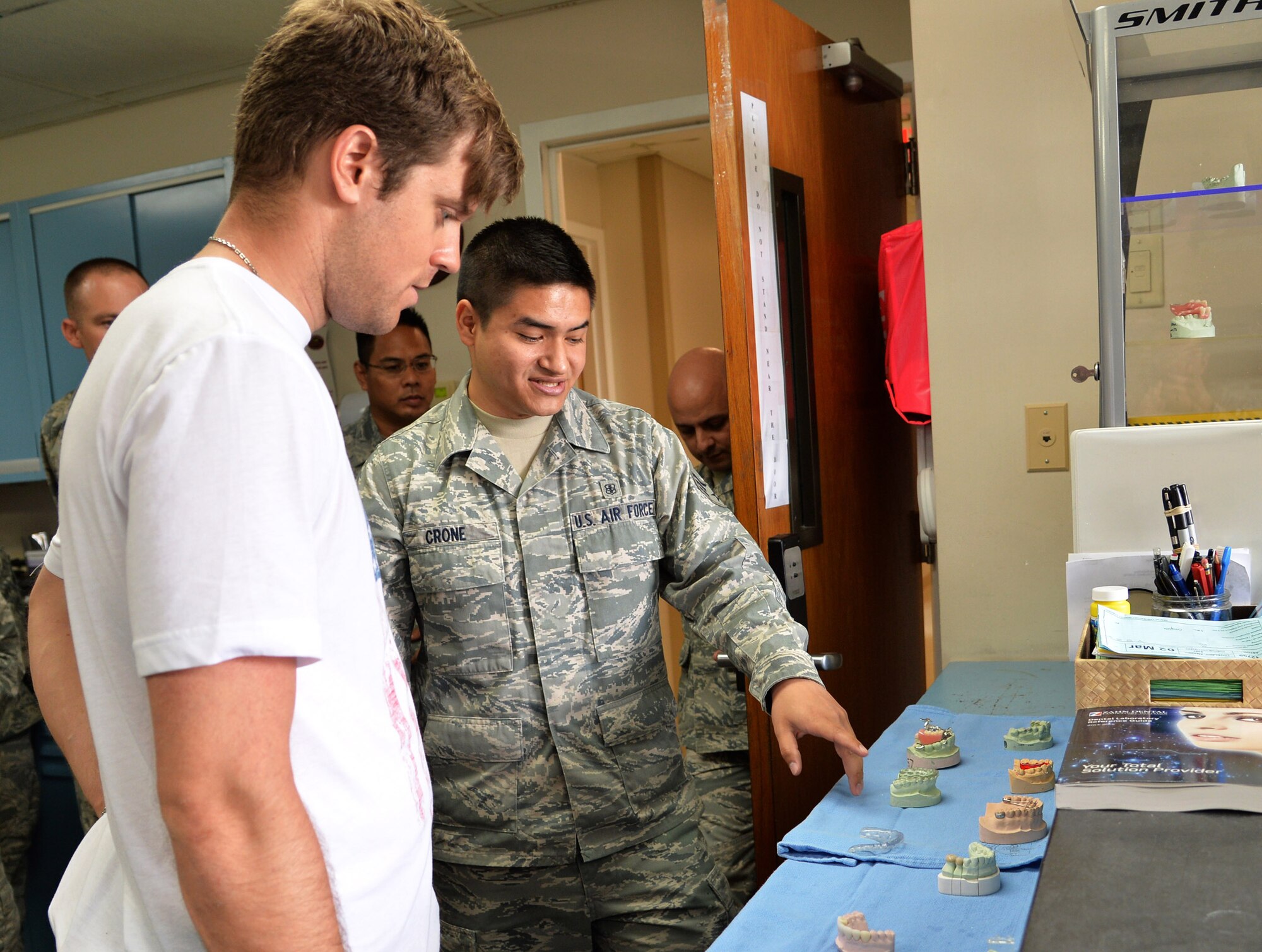 U.S. Olympic snowboarder Alex Deibold listens as Senior Airman Kevin Crone, 15th Medical Group, explains the different types of dental services his section performs during a tour of the 15th Wing at Joint Base Pearl Harbor-Hickam, Hawaii, April 15, 2014. Deibold, a Sochi Olympic bronze medal winner, toured wing units and Airmen as part of a program sponsored by the 300 Warrior Support Organization. (U.S. Air Force photo/Staff Sgt. Alexander Martinez)