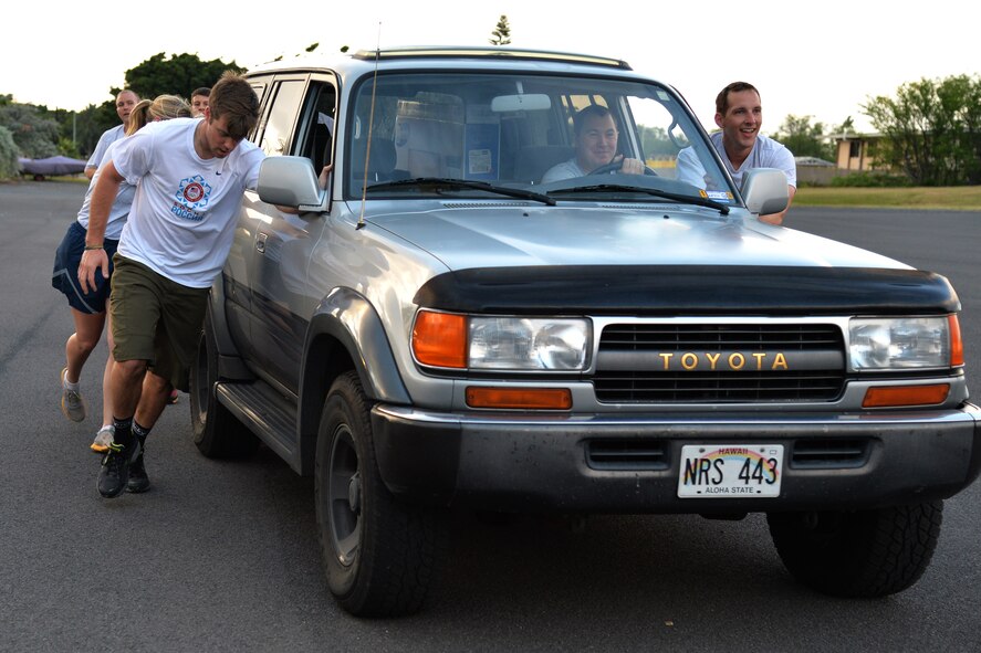 U.S. Olympic snowboarder Alex Deibold (left) helps push a vehicle during a physical training session activity at Joint Base Pearl Harbor-Hickam, Hawaii, April 15, 2014. Deibold, a Sochi Olympic bronze medal winner, toured 15th Wing units and Airmen as part of a program sponsored by the 300 Warrior Support Organization. (U.S. Air Force photo/Staff Sgt. Alexander Martinez)