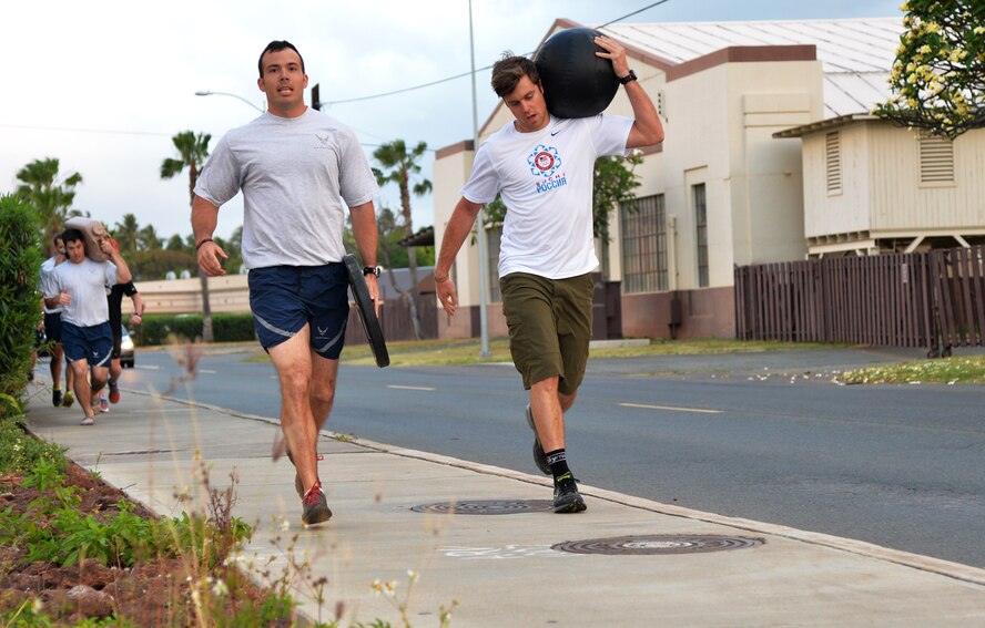 From left: Capt. Michael Kerschbaum, 154th Operations Group , and U.S. Olympic snowboarder Alex Deibold carry weighted objects during a physical training session run at Joint Base Pearl Harbor-Hickam, Hawaii, April 15, 2014. Deibold, a Sochi Olympic bronze medal winner, toured 15th Wing units and Airmen as part of a program sponsored by the 300 Warrior Support Organization. (U.S. Air Force photo/Staff Sgt. Alexander Martinez)