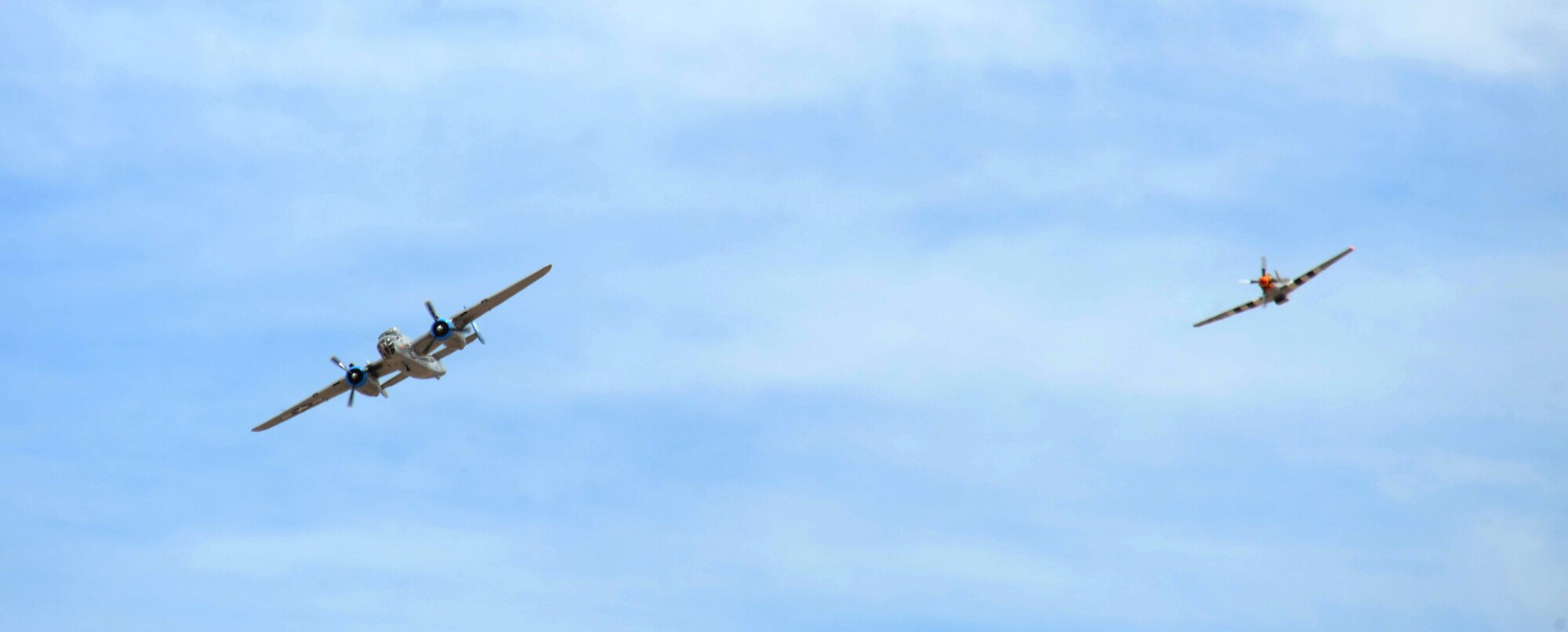 A P-51 Mustang and a B-25 Mitchell fly together during the Thunder and Lightning over Arizona Open House at Davis-Monthan Air Force Base, Ariz., April 12, 2014.  D-M held the two-day event to show appreciation by opening its gates and allowing the general public to learn more about the U.S. Air Force while viewing aerial demonstrations. (U.S. Air Force photo by Airman 1st Class Chris Massey/Released)