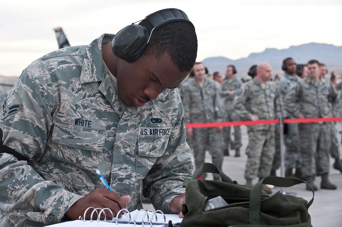 Airman 1st Class Akeem White, 757th Aircraft Maintenance Squadron, Strike Aircraft Maintenance Unit load crew member, goes through his check list during a load crew competition on the flightline April 11, 2014, at Nellis Air Force Base, Nev. Load crew competitions are conducted quarterly to keep Airmen sharp and recognize superior performers. (U.S. Air Force photo by Senior Airman Matthew Lancaster)