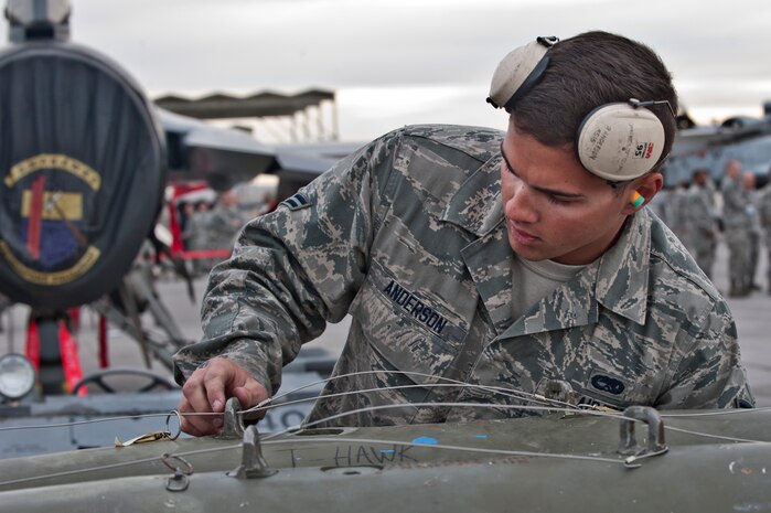 Airman 1st Class Ryan Anderson, 57th Aircraft Maintenance Squadron, Tomahawk Aircraft Maintenance Unit load crew member, inspects an MK-82 bomb during a load crew competition on the flightline April 11, 2014, at Nellis Air Force Base, Nev. The load crew competition boosts morale and promotes an environment of friendly competition. (U.S. Air Force photo by Senior Airman Matthew Lancaster)