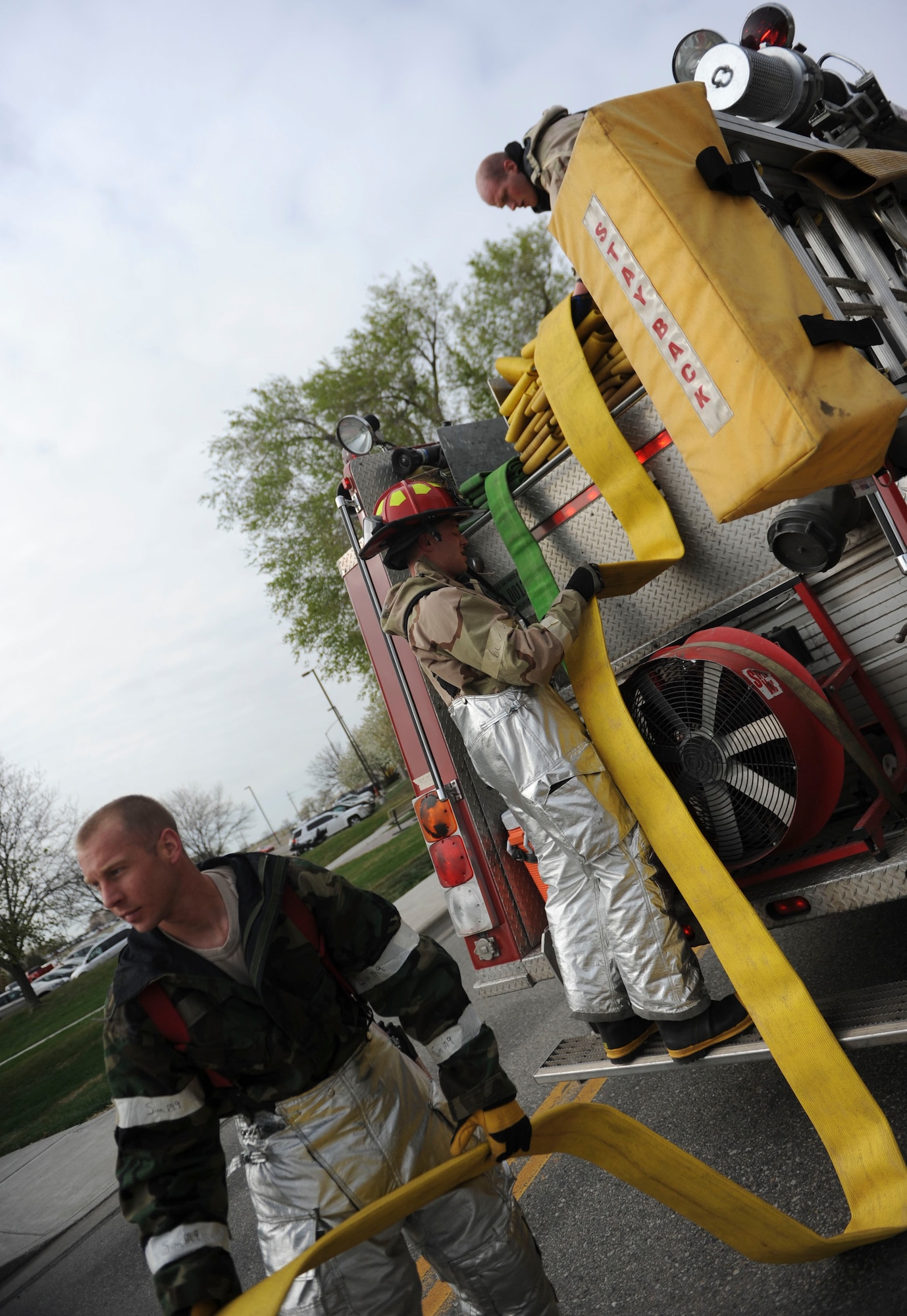 Firefighters from the 366th Civil Engineer work together during a simulated fire while working in full chemical gear April 16, 2014, Mountain Home Air Force Base, Idaho. Whenever the giant voice system announces the new defensive measures, Airmen quickly transition to the new posture and complete the mission to the highest degree possible. (U.S. Air Force photo by Airman 1st Class Malissa Lott/RELEASED)
