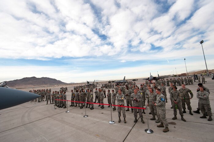 Spectators watch the load crew teams from the various aircraft maintenance units load weapons onto aircraft during the 57th Wing’s quarterly load crew competition, April 11, 2014, at Nellis Air Force Base, Nev. In addition to the Airmen honing their skills, the load crew competition promotes camaraderie with friendly competition. (U.S. Air Force photo by Airman 1st Class Thomas Spangler)