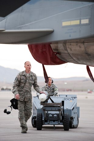 Staff Sgt. Kyle Britton (front), a 757th Aircraft Maintenance Squadron, Eagle Aircraft Maintenance Unit load crew team chief, and 757th AMXS load crew member Senior Airman Khanh Mai (back), load an inert munition onto an F-15 Strike Eagle during the quarterly load crew competition on the flightline, April 11, 2014, at Nellis Air Force Base, Nev. Weapons load teams are evaluated to ensure they properly follow checklist, safety and accuracy. (U.S. Air Force photo by Airman 1st Class Thomas Spangler)