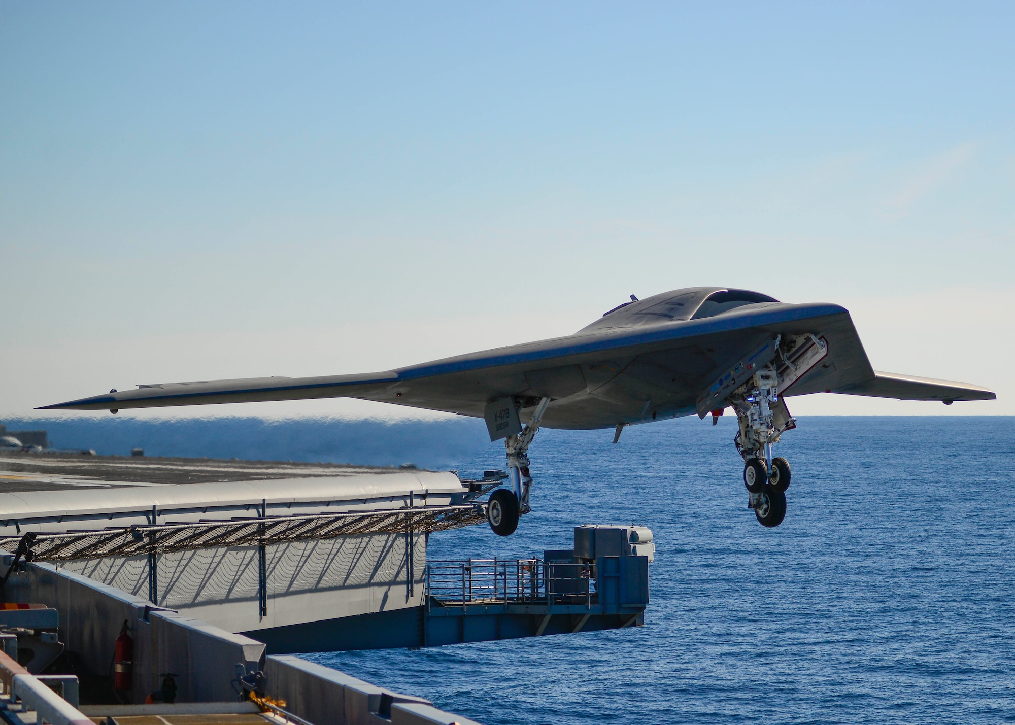 The second X-47B performs a touch-and-go onboard the USS Theodore Roosevelt during an at-sea testing period in November 2013. The aircraft performed numerous catapulted take-offs, touch-and-goes and arrested landings to demonstrate its precision approach and landing characteristics in various adverse wind conditions.  (Northrop Grumman photo by Alan Radecki)