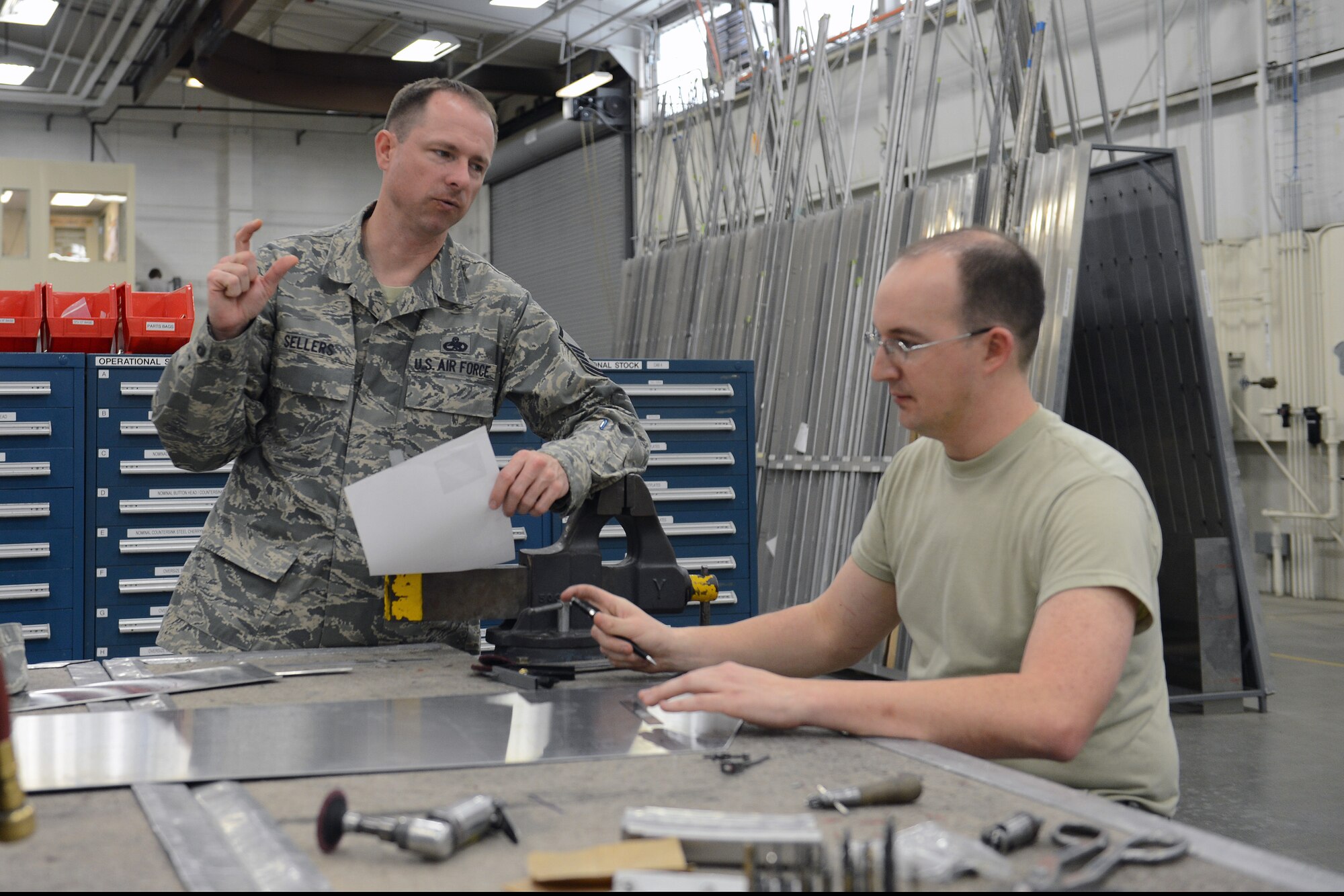 Master Sgt. Marc Sellers (left), 62nd Maintenance Squadron fabrication flight chief, overlooks the repair of a C-17 Globemaster III panel by Tech. Sgt. Matt Benhart, 62nd MXS aircraft structural maintenance craftsmen, April 8, 2014 at Joint Base Lewis-McChord, Wash. Sellers was selected as Air Mobility Command's senior non-commissioned officer nominee for the Air Force's 12 Outstanding Airmen of the Year.(U.S. Air Force photo/Airman 1st Class Jacob Jimenez)      