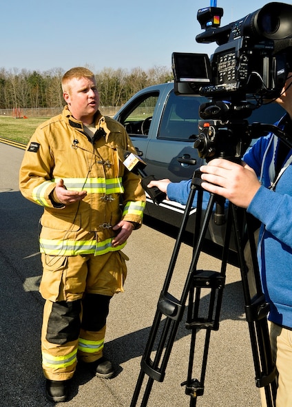 U.S. Air Force Staff Sgt. Taylor Webb, a firefighter with the 182nd Civil Engineer Squadron, gives an interview to local media after a mass-casualty exercise in Peoria, Ill., April 12, 2014. An Illinois Air National Guard C-130 Hercules was used to imitate an aircraft crash with 50 casualties on a Gen. Wayne A. Downing Peoria International Airport runway. The airport hosted the tri-annual exercise to test its emergency protocols. Several emergency-response agencies, including the 182nd Civil Engineer Squadron fire department, also participated in the exercise to practice their procedures and training. (U.S. Air National Guard photo by Staff Sgt. Lealan Buehrer/Released)