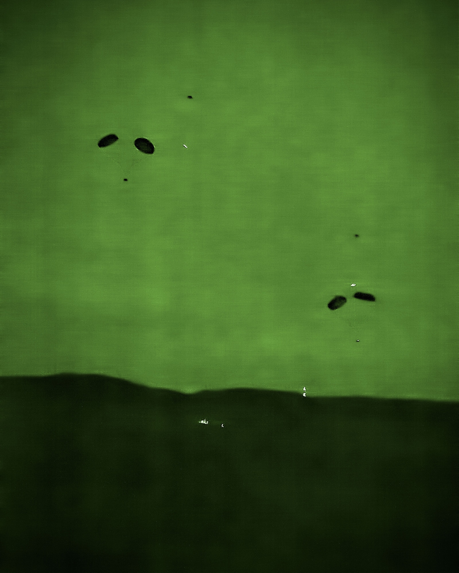 Pallets drop to the Fort McCoy, Wis., landing zone right on target after being deployed from a 934th Airlift Wing C-130 aircraft.  The weekend training mission for the 96th Airlift Squadron and 27th Aerial Port Squadron included preparing and deploying air drops, unscheduled landings, operating in night vision environment and deploying flares.  (U.S. Air Force photo by Shannon McKay/Released)