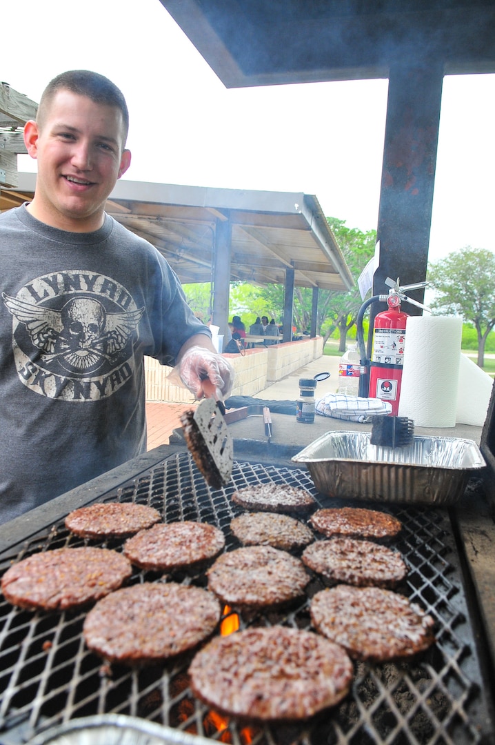 Senior Airman Nathan Tingley flips burgers at the inaugural Air Force Intelligence, Surveillance and Reconnaissance Agency Field Day and Family Picnic at Security Hill's Stapleton Park April 5. The event is the unit's way of saying thanks to all who have sacrificed on its behalf. (U. S. Air Force photo by William Belcher) 