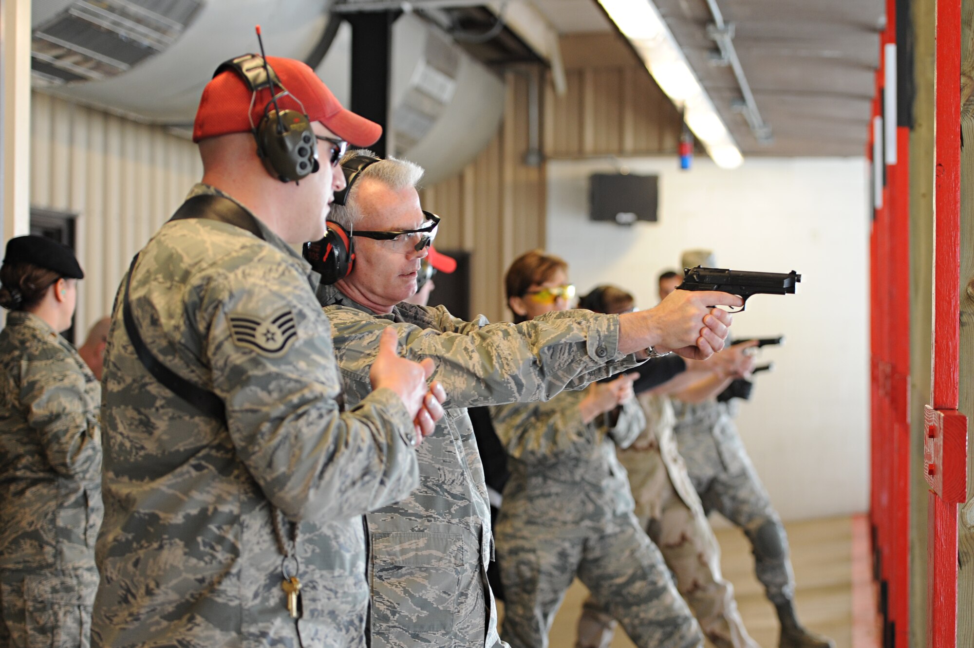 Staff Sgt. Garrett Nale, 375th Security Forces Squadron combat arms training and maintenance member, assists Gen. Paul Selva, Air Mobility Command commander, during a shooting exercise at Scott Air Force Base, Ill. on April 10, 2014. Selva attended some of the training sessions during a week-long training aimed at higher training standards. (U.S. Air Force photo/Senior Airman Sarah Hall-Kirchner)