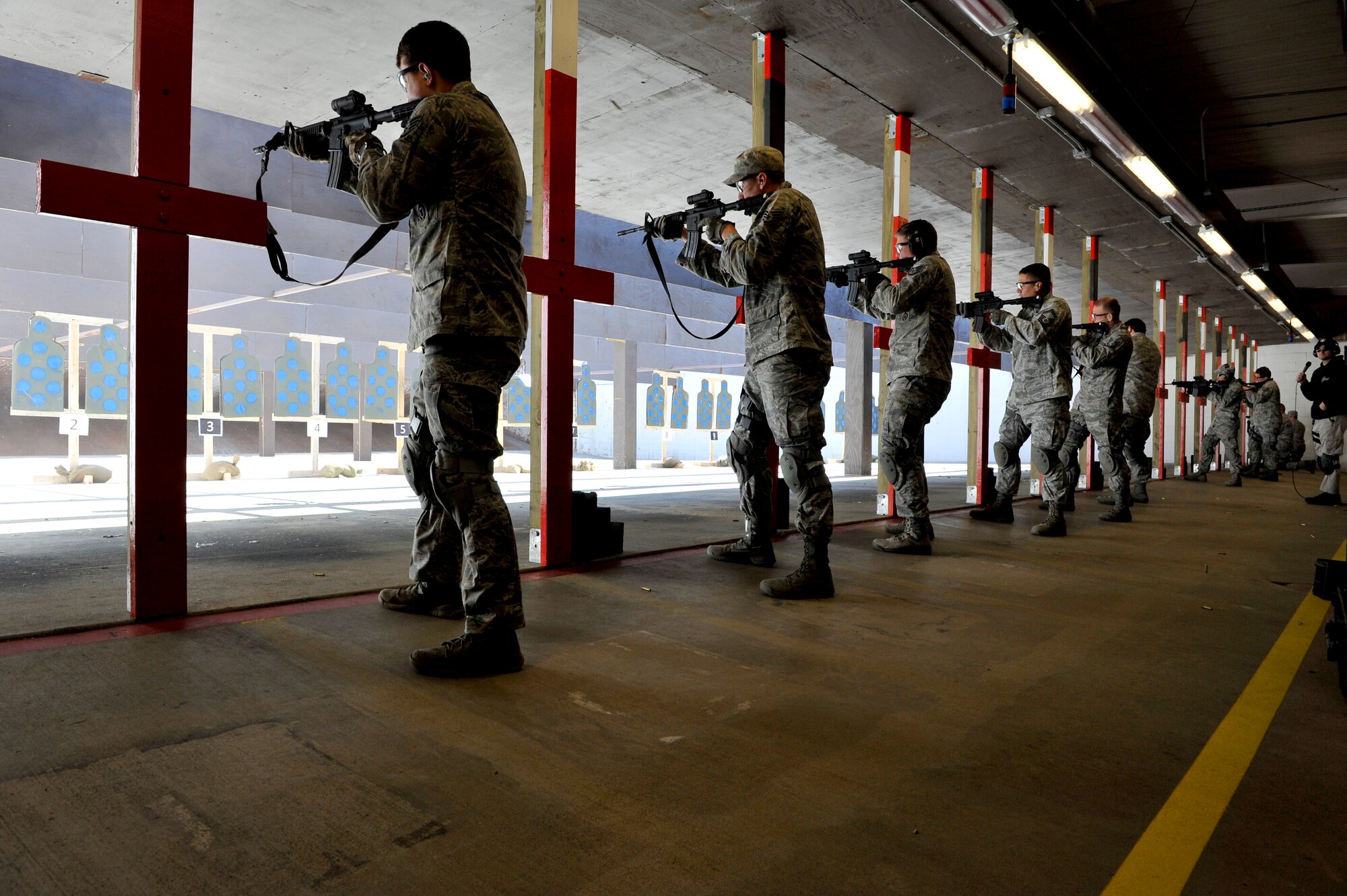 Security Forces Squadron trainers practice multiple stances during a firing exercise for Progressive Combat Solutions training at Scott Air Force Base, Ill., April 8, 2014. The Progressive Combat Solutions trains military and law enforcement personnel in decision making process originally benchmarked by the Air Force known as observe, orient, decide and act. The Air Mobility Command and the 375th Security Force Squadron hosted this training with the goal of implementing it across the AMC command in the future. (U.S. Air Force photo/Airman 1st Class Kiana Brothers)